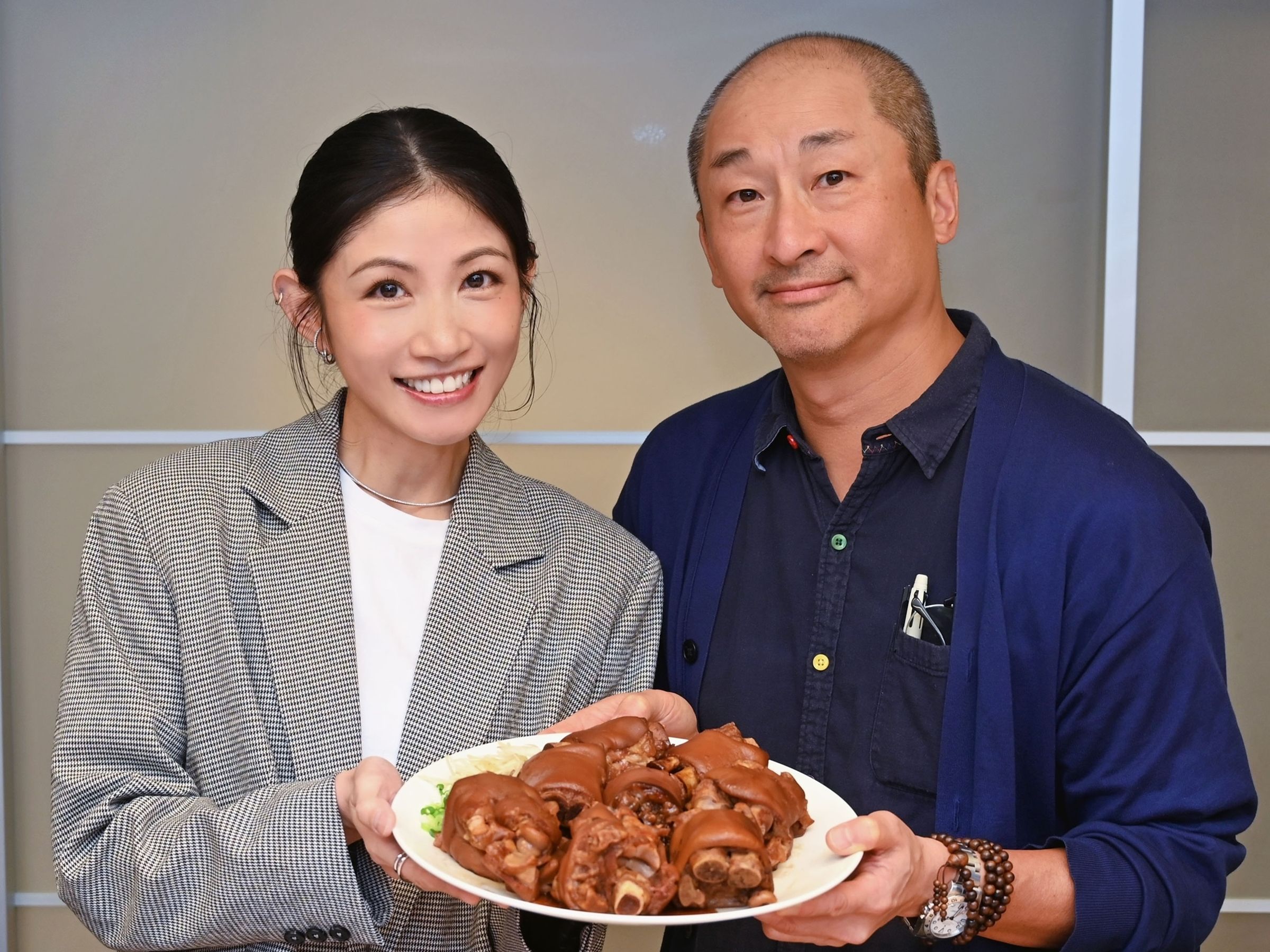 李千娜（左）開心準備豬腳與環球音樂再度合作，右為環球集團臺灣董事總經理謝定原。（環球音樂提供）