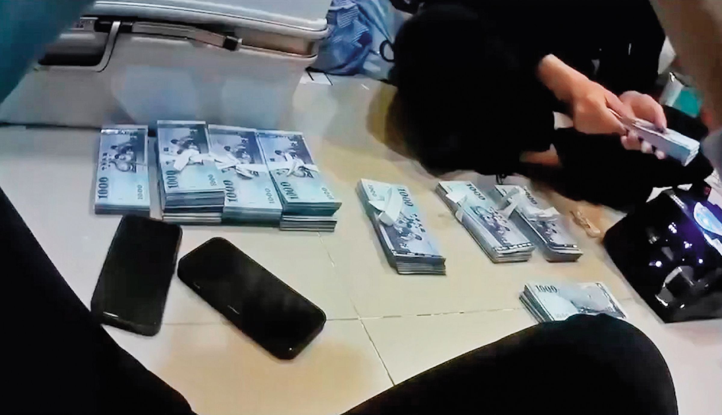 警方到李女在台中承租的小豪宅搜索,於保險箱查扣300多萬元贓款及提款卡等證物。(翻攝畫面)