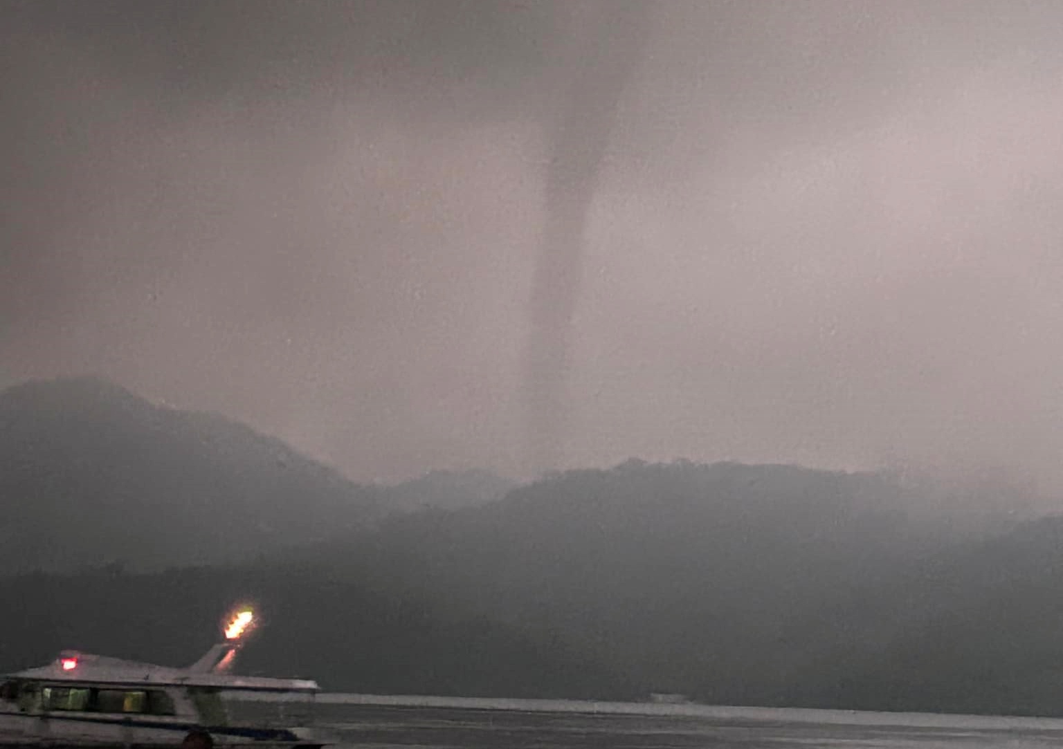 一名民眾16日傍晚在日月潭捕捉到疑似為龍捲風的天氣現象。（翻攝自臉書社團《爆料公社二社》）