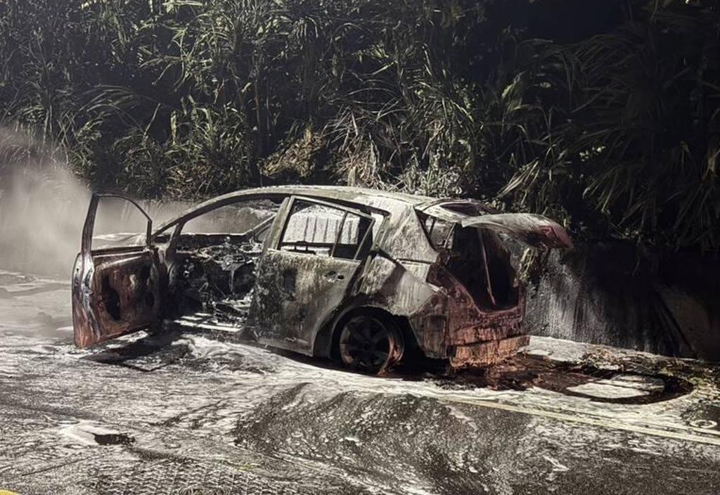 海巡官兵昨日執行勤務，見一輛轎車有異狀，強行將車上一對男女拖出來後，車子就燒成只剩骨架。（翻攝畫面）