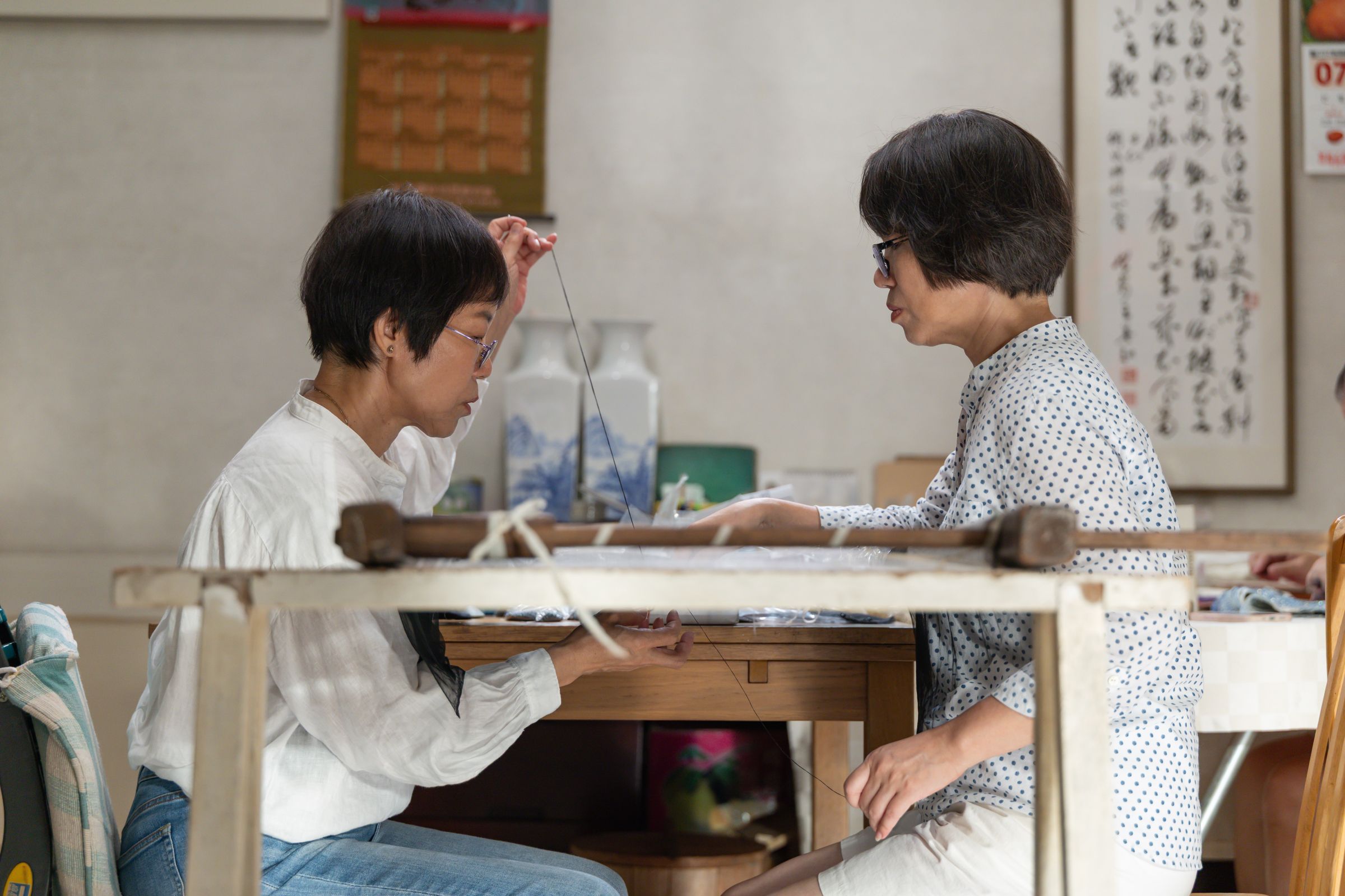 《匠人魂》第63集「天衣無縫」,介紹胡梅花(左)胡梅蘭(右)姊妹靠一針一線的珠繡勾勒出台灣流行文化的絕代風華。(文總提供)