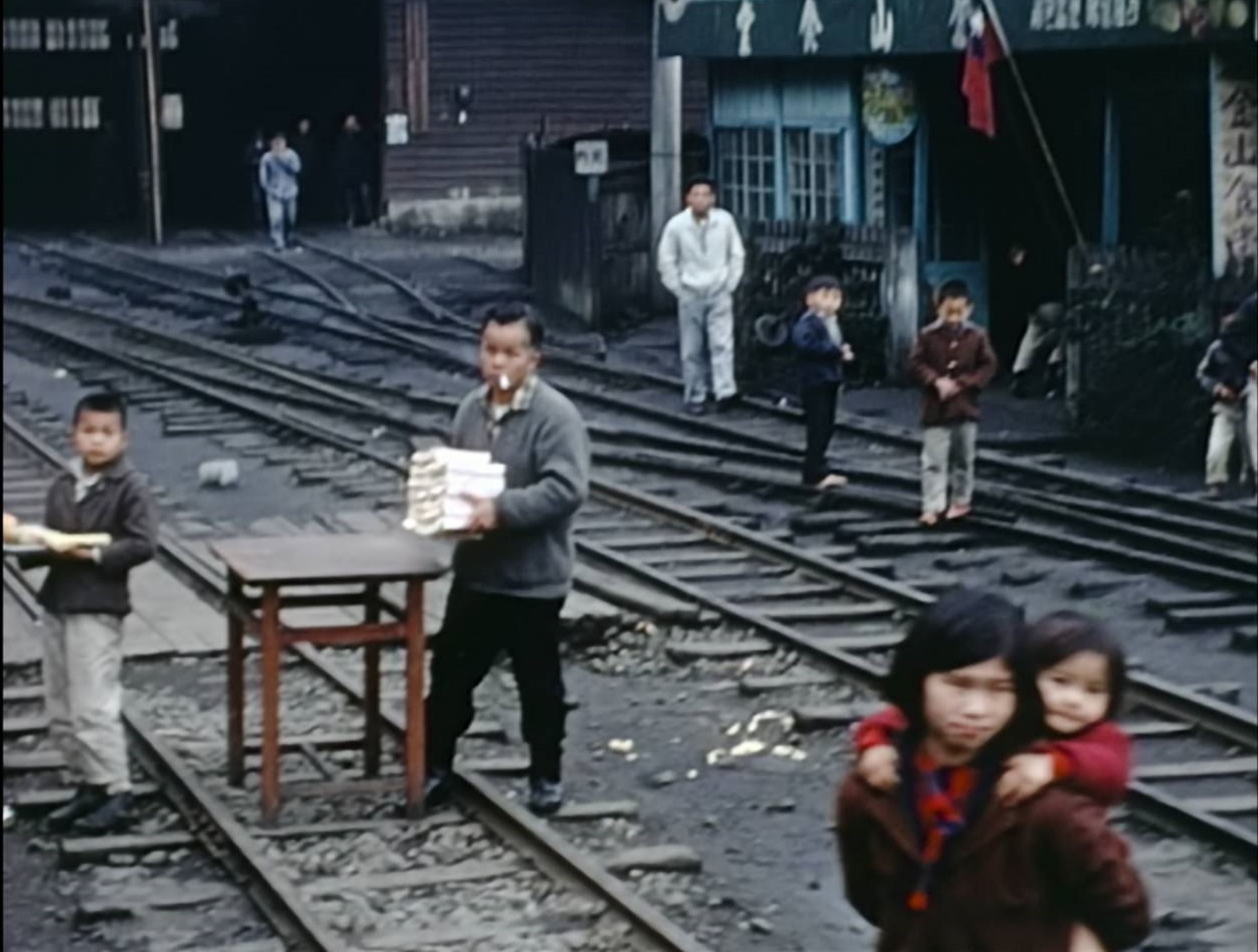 1976年NHK拍攝的阿里山紀錄片，捕捉奮起湖飯店第一代林儀芳（左二）賣便當的身影。（NHK資料照）
