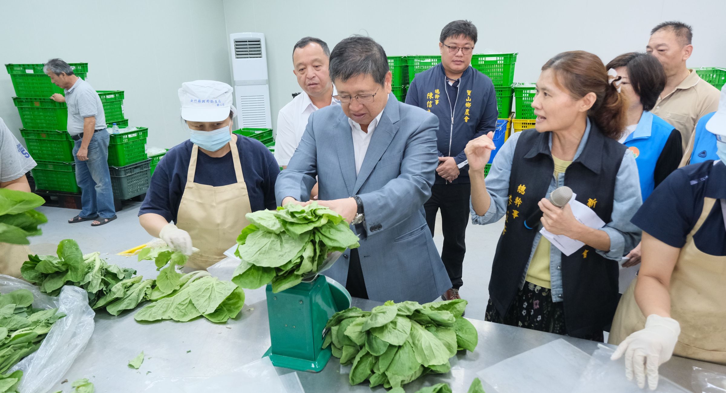 新竹縣長楊文科到縣農會協助分裝有機蔬菜。(新竹縣政府提供)