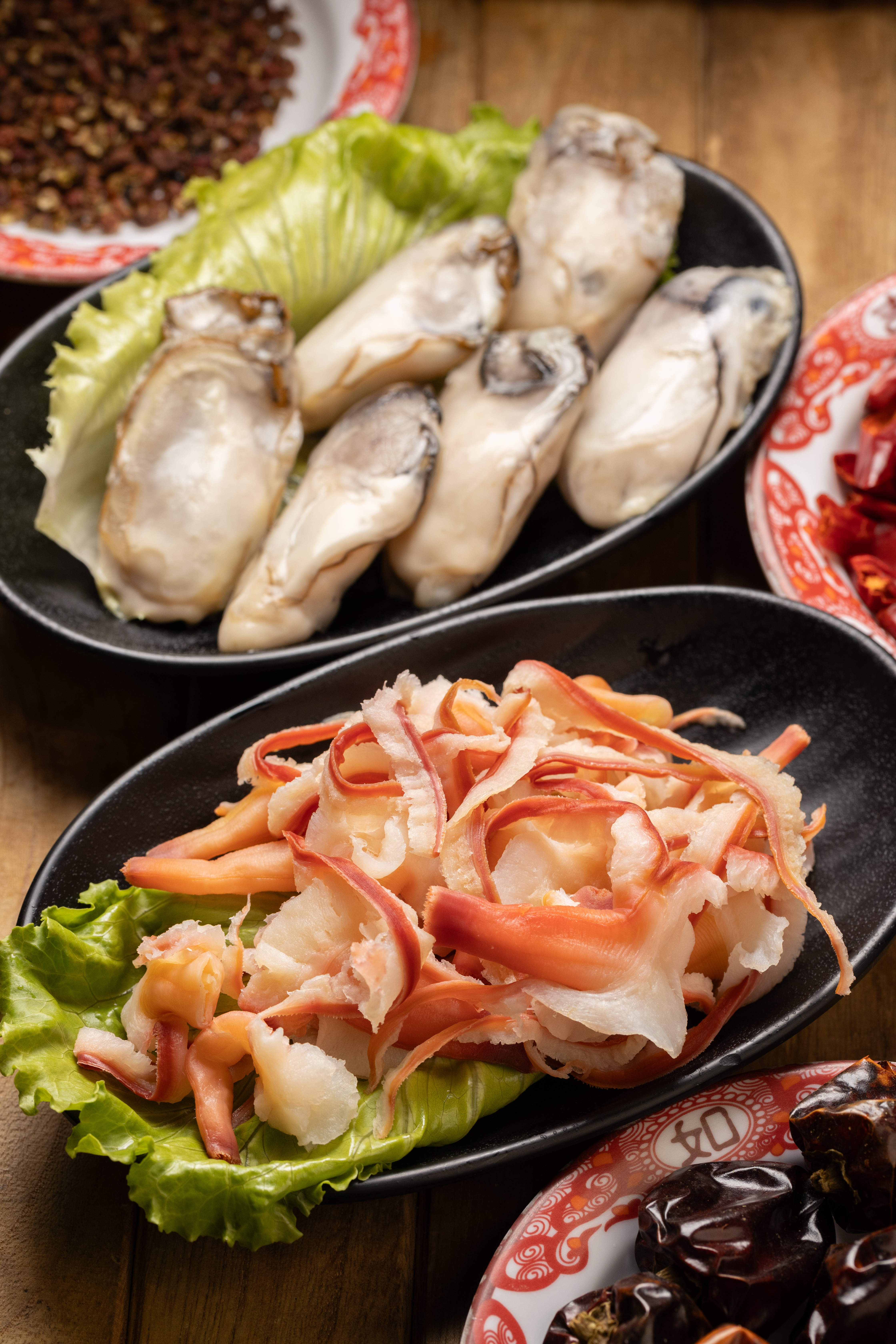 季節限定的「蘭花蚌」（前，200元／份）彈牙有嚼勁；「韓國生蠔清肉」（後，150元／份）大顆鮮美、入口軟嫩。