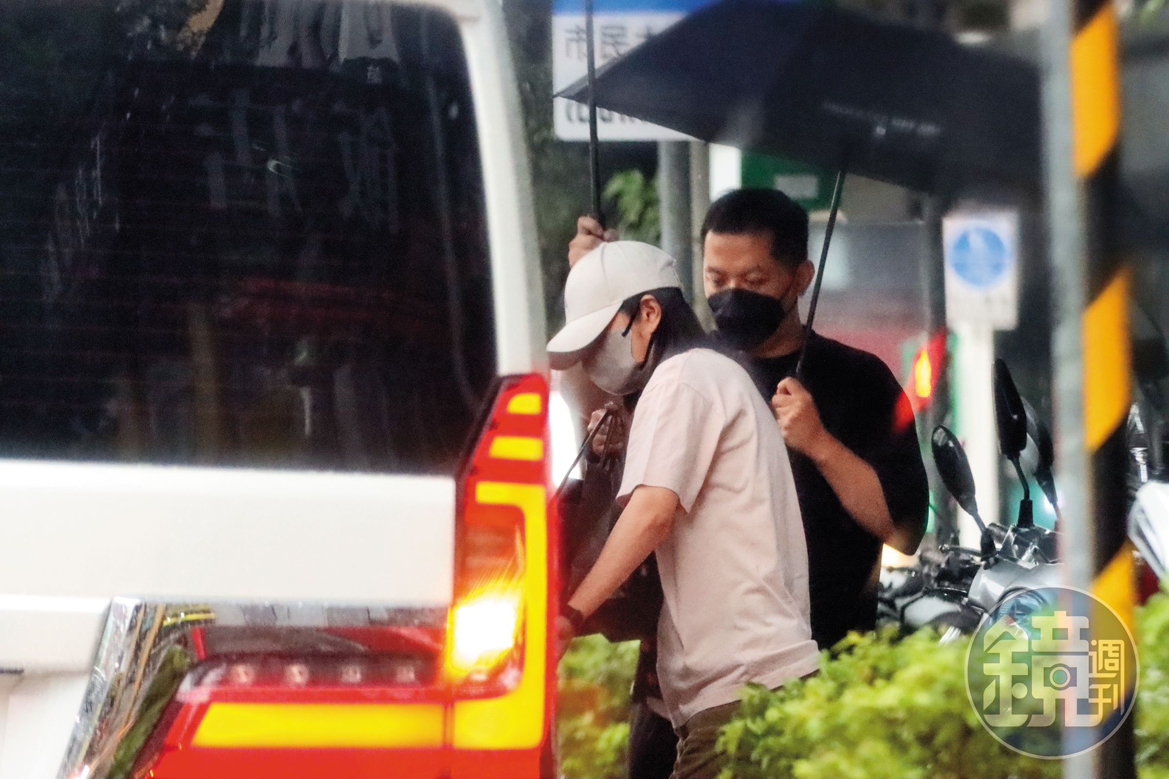 8/15 16:06 安以軒(左)在司機撐傘護送下衝上廂型車,出發去接兒女放學。
