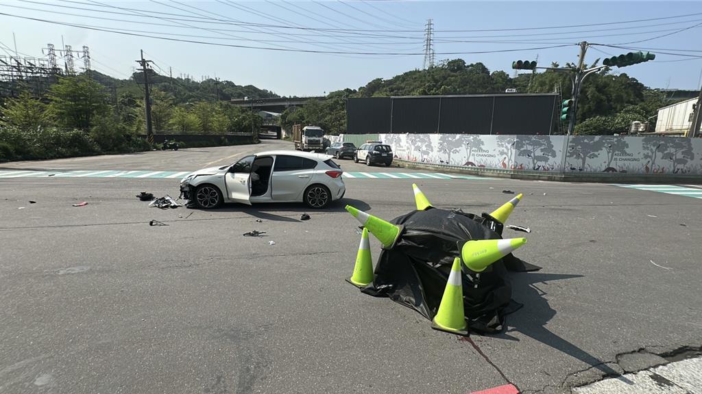 基隆七堵區今天發生汽車和機車碰撞事故，造成機車騎士慘死，警方將死者遺體用黑布覆蓋。（翻攝畫面）