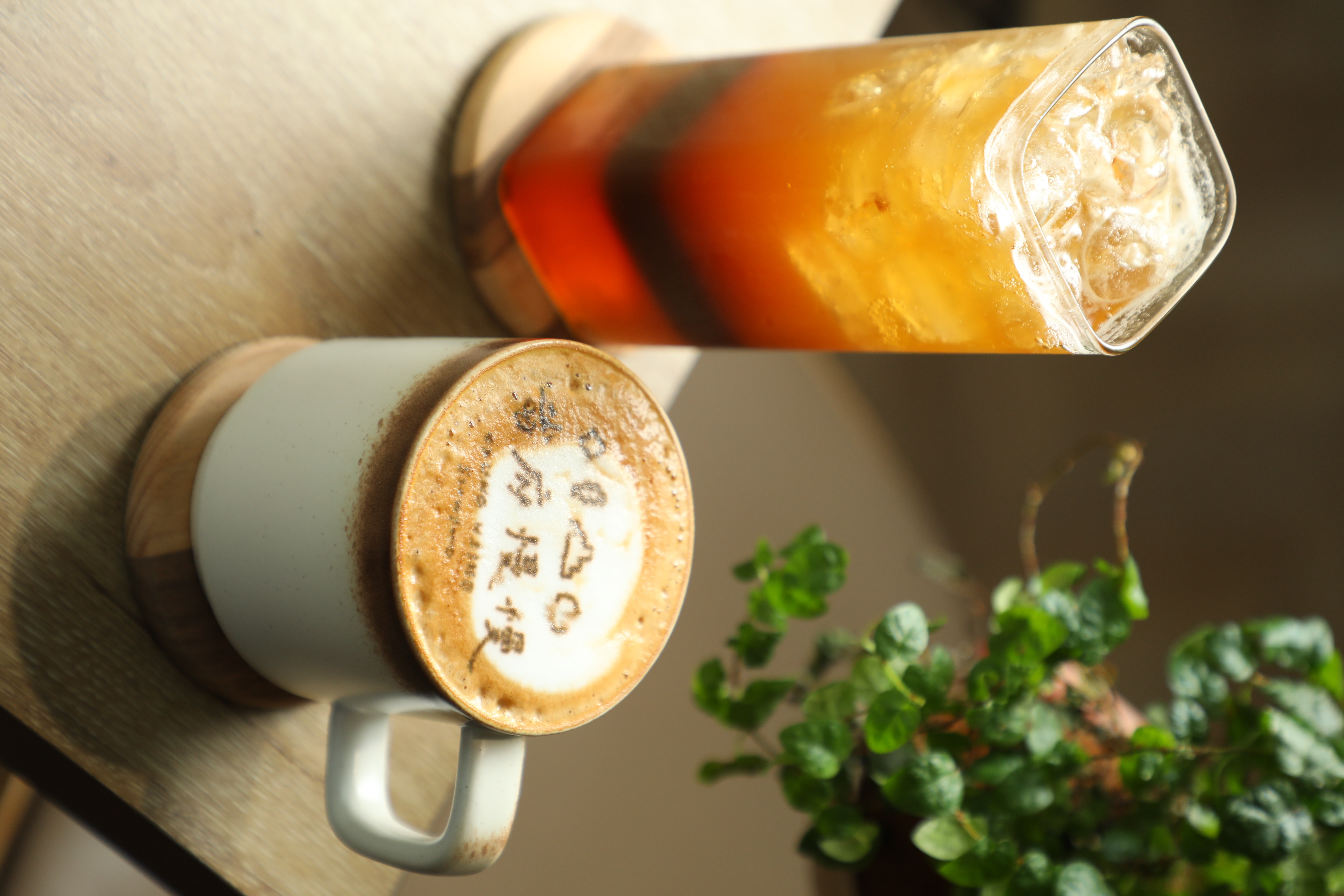 用在地小農牛奶製作的「拿鐵咖啡」（右，90元／杯）與用省府烏梅與中寮柳橙調配的「美式咖啡氣泡」（左，120元／杯）。