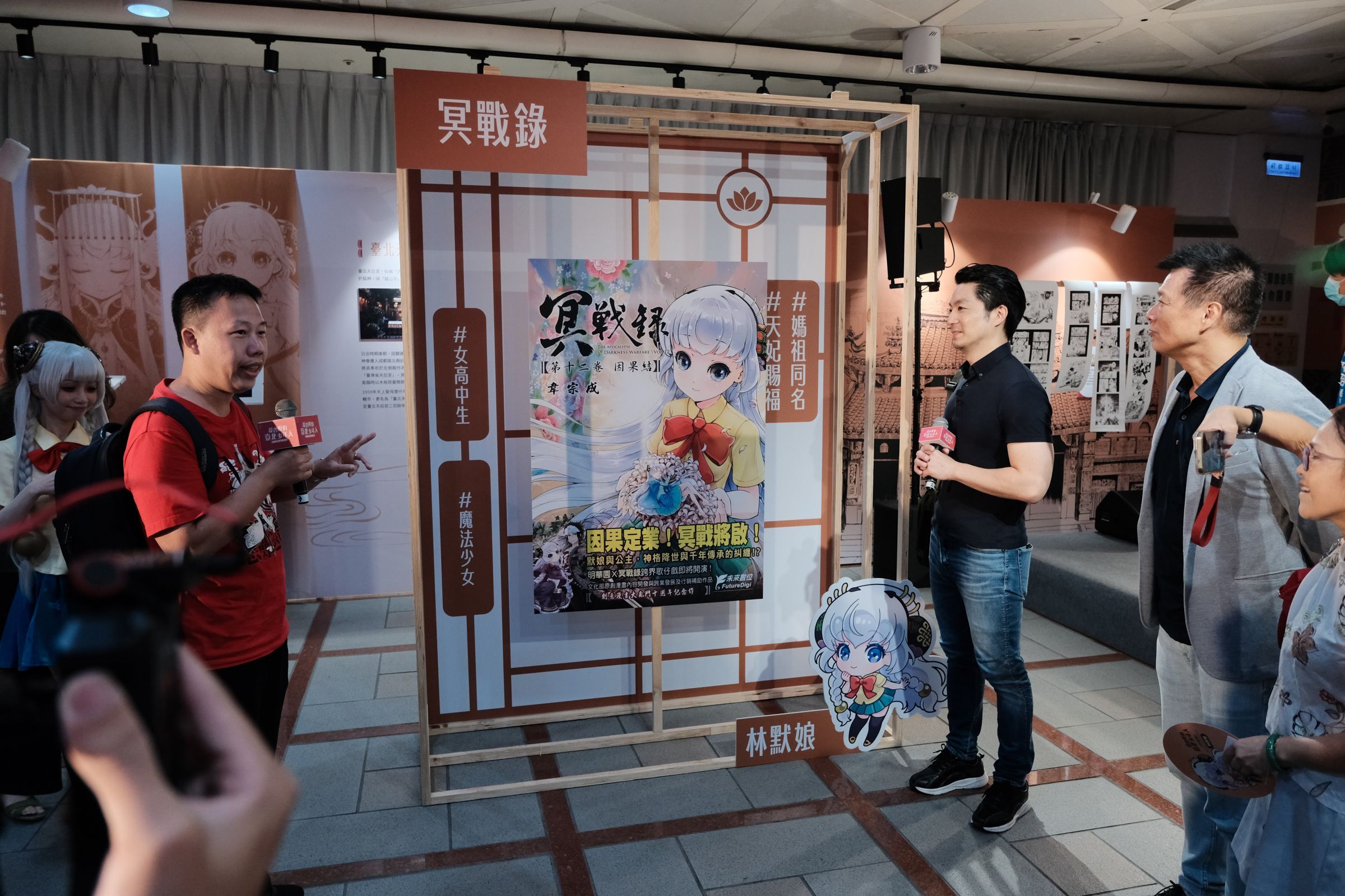 漫畫家韋宗成(左1)向台北市長蔣萬安(右3)、台北市文化局局長蔡詩萍(右2)、台北市議員郭昭巖(右1)介紹《冥戰錄》。(台北市文化局提供)