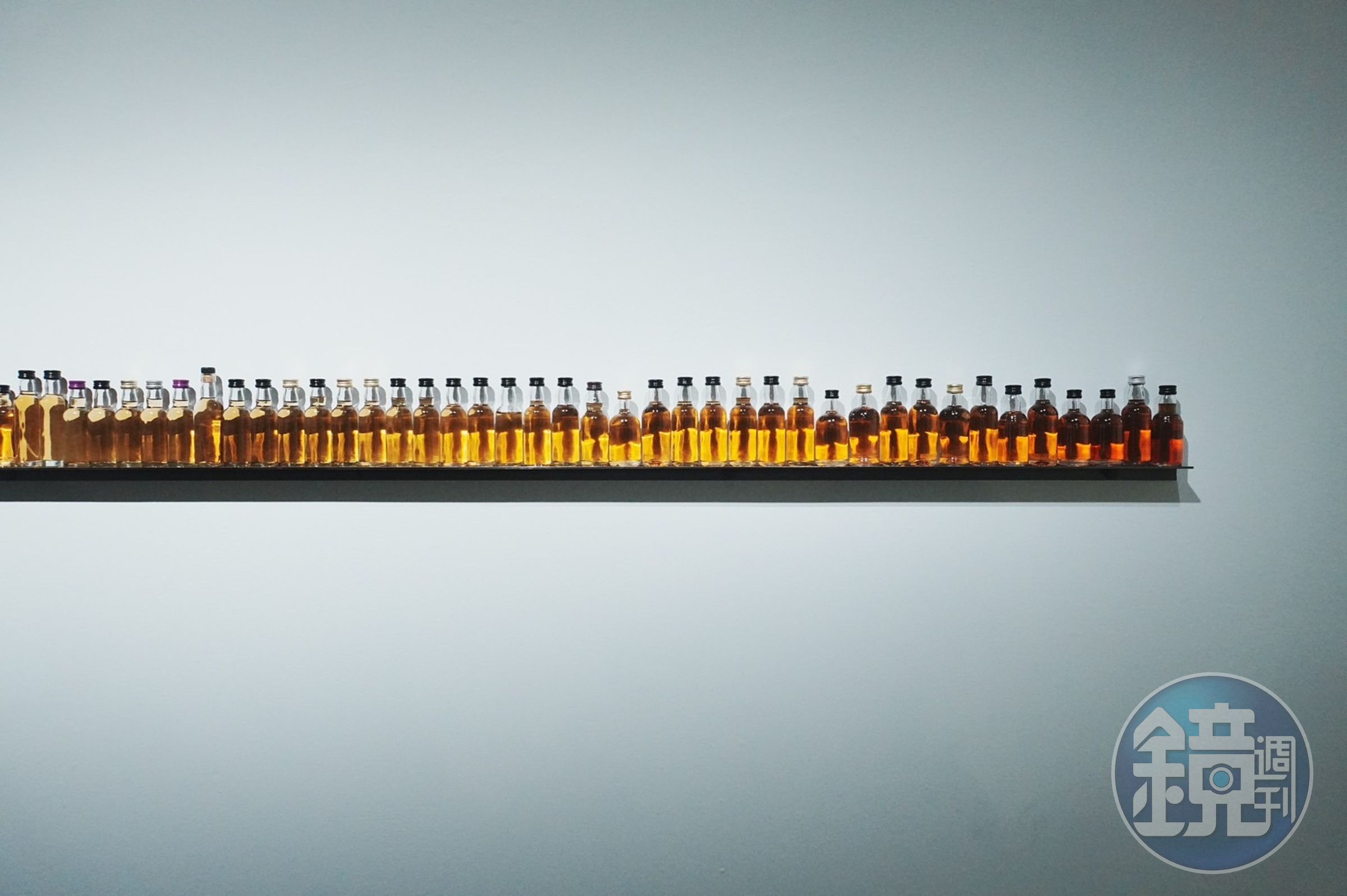 李明學的作品《Frequency》以試飲瓶排列成漸層彩象徵威士忌製程中時間的沉澱與變化，也反映出記憶中的層次與未來的無限可能性。 