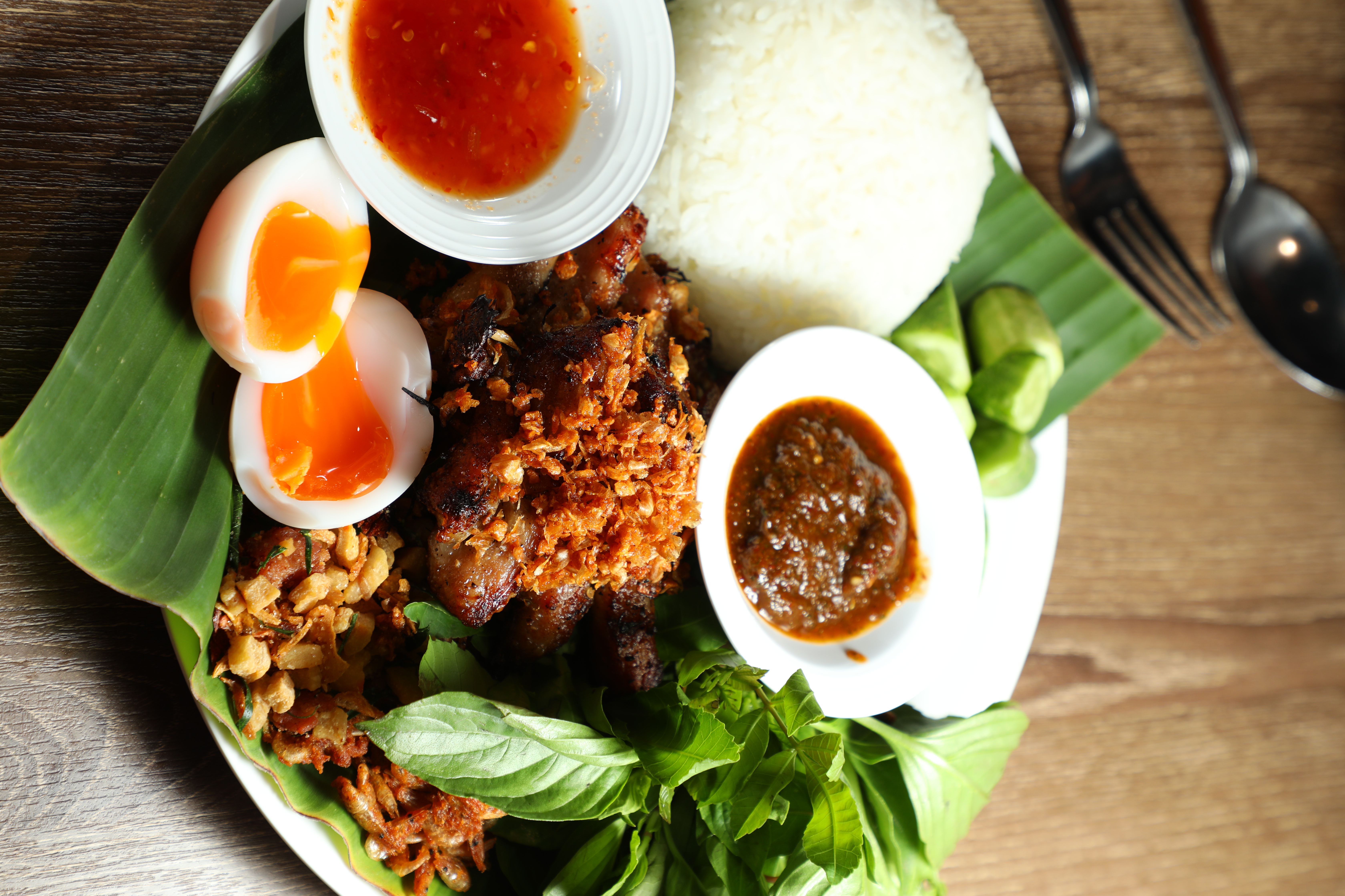 「坤泰國東北菜Krumn By Phed Phed」的「Grilled Pork烤豬肉飯」最精彩的毫無油耗味的豬油渣。（160泰銖／份，約NT$141）