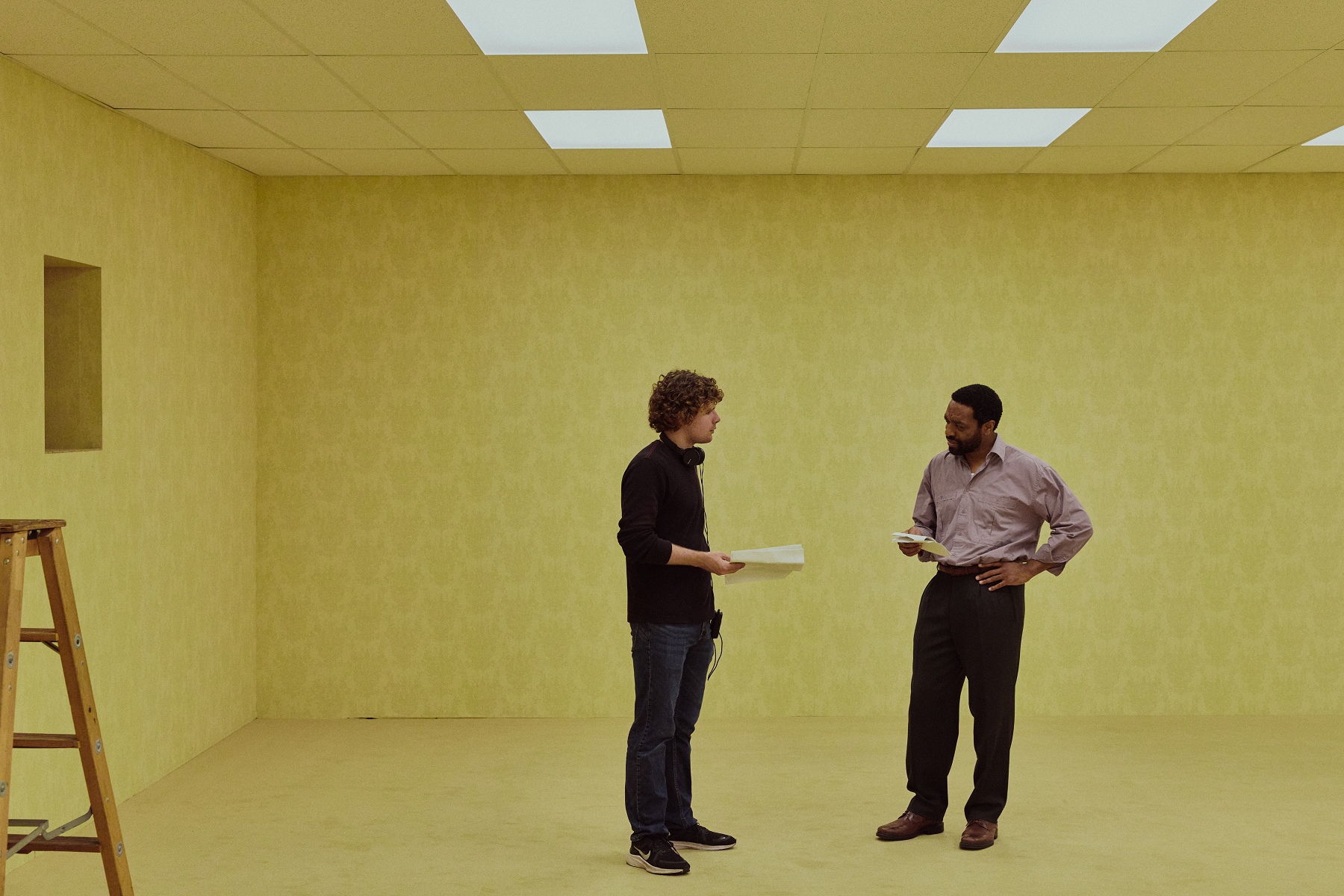 劇組搭建超過三萬平方英尺的「實體後室」場景，透過角色視角展現被切割的生活，演員迷失在由無盡黃色壁紙包圍、錯綜複雜的重複空間中。（采昌提供）