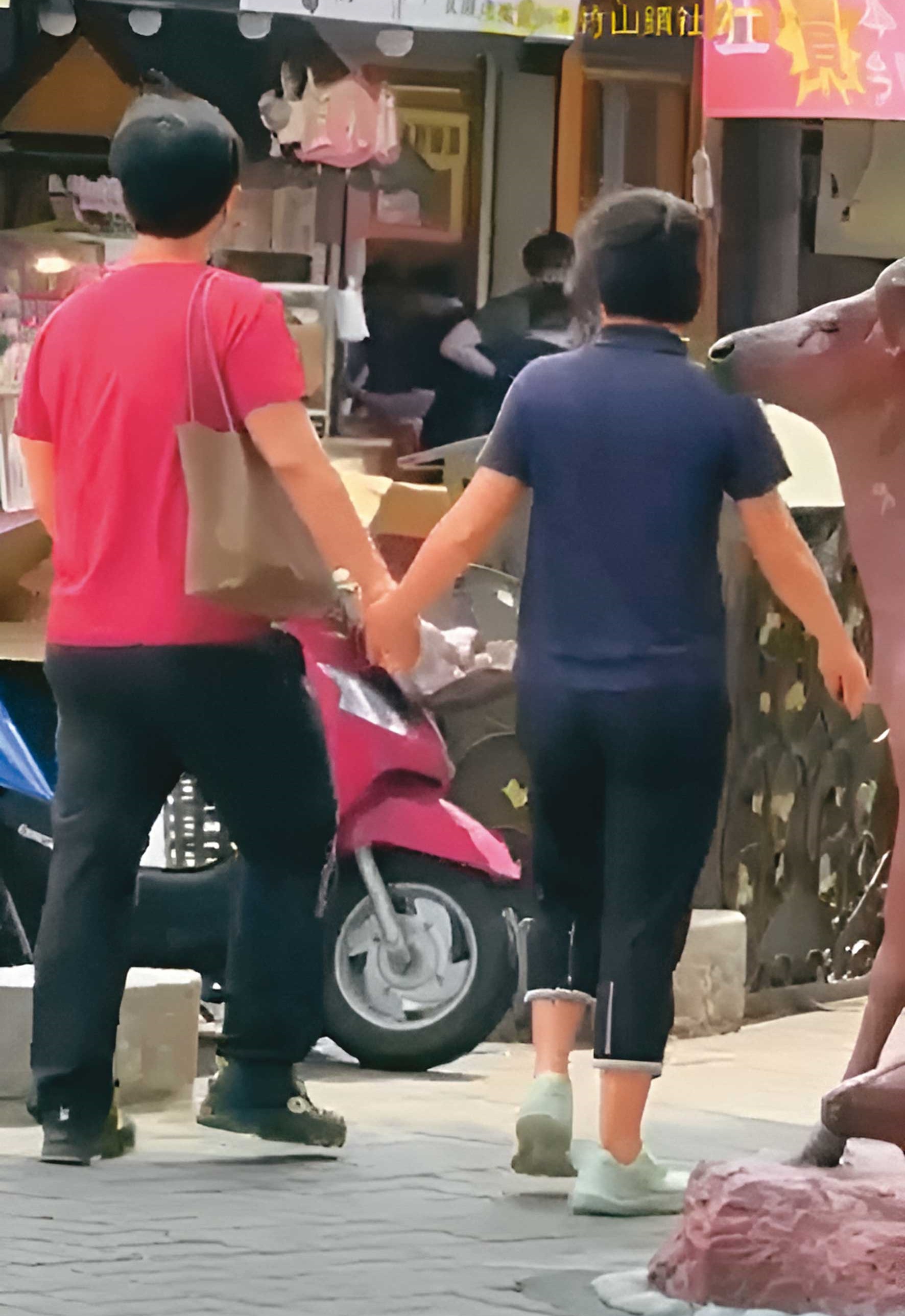 已婚政風主任L男(左)與法官助理K女(右)被直擊當街牽手。(讀者提供)