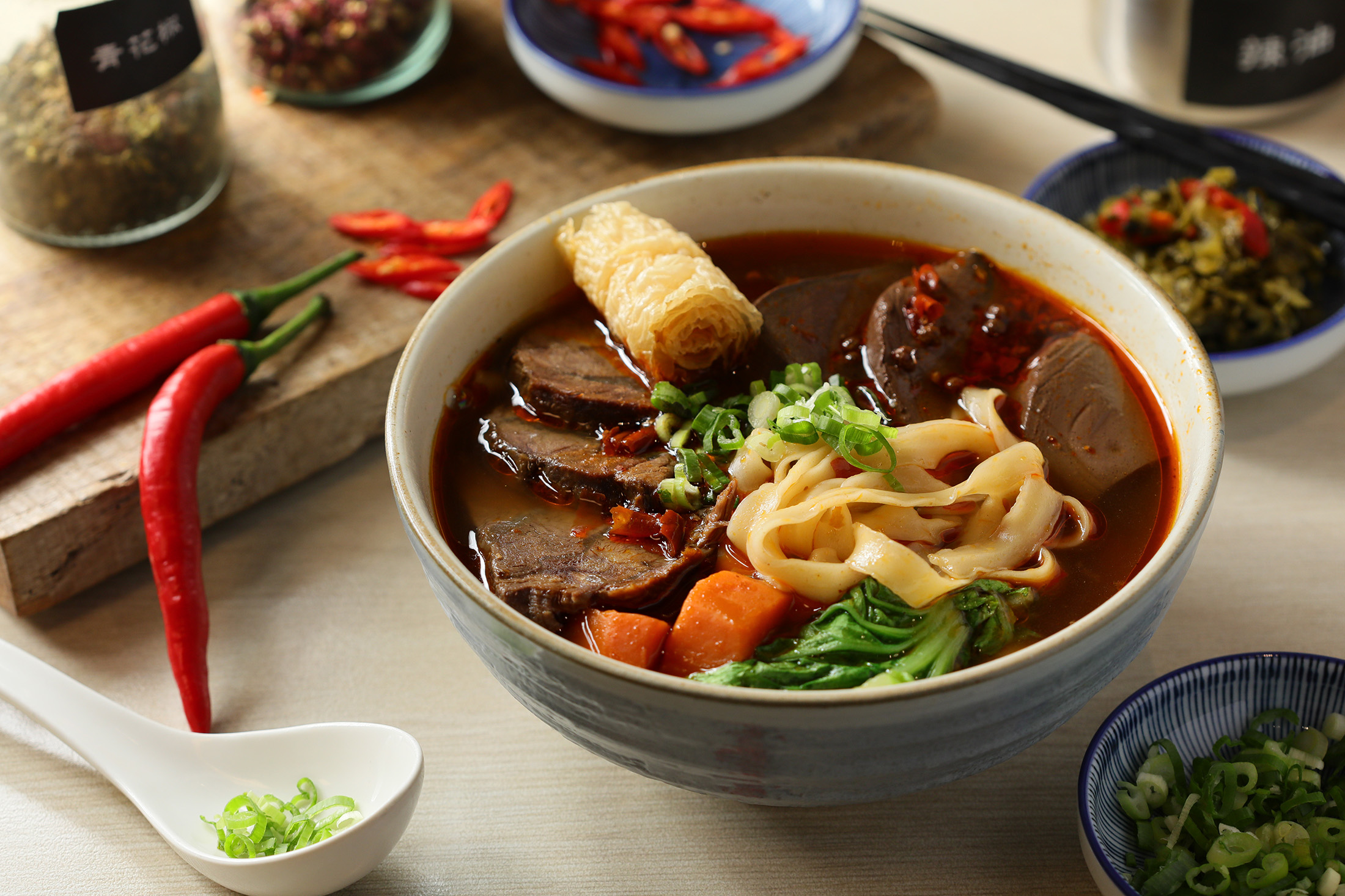 「竣師父牛肉麵」的「麻辣鴨血牛肉麵（寬麵）」以自家炒製的麻辣鍋底熬煮麻辣鴨血，搭配紅燒牛肉麵，讓人越吃越上癮。（265元／碗）