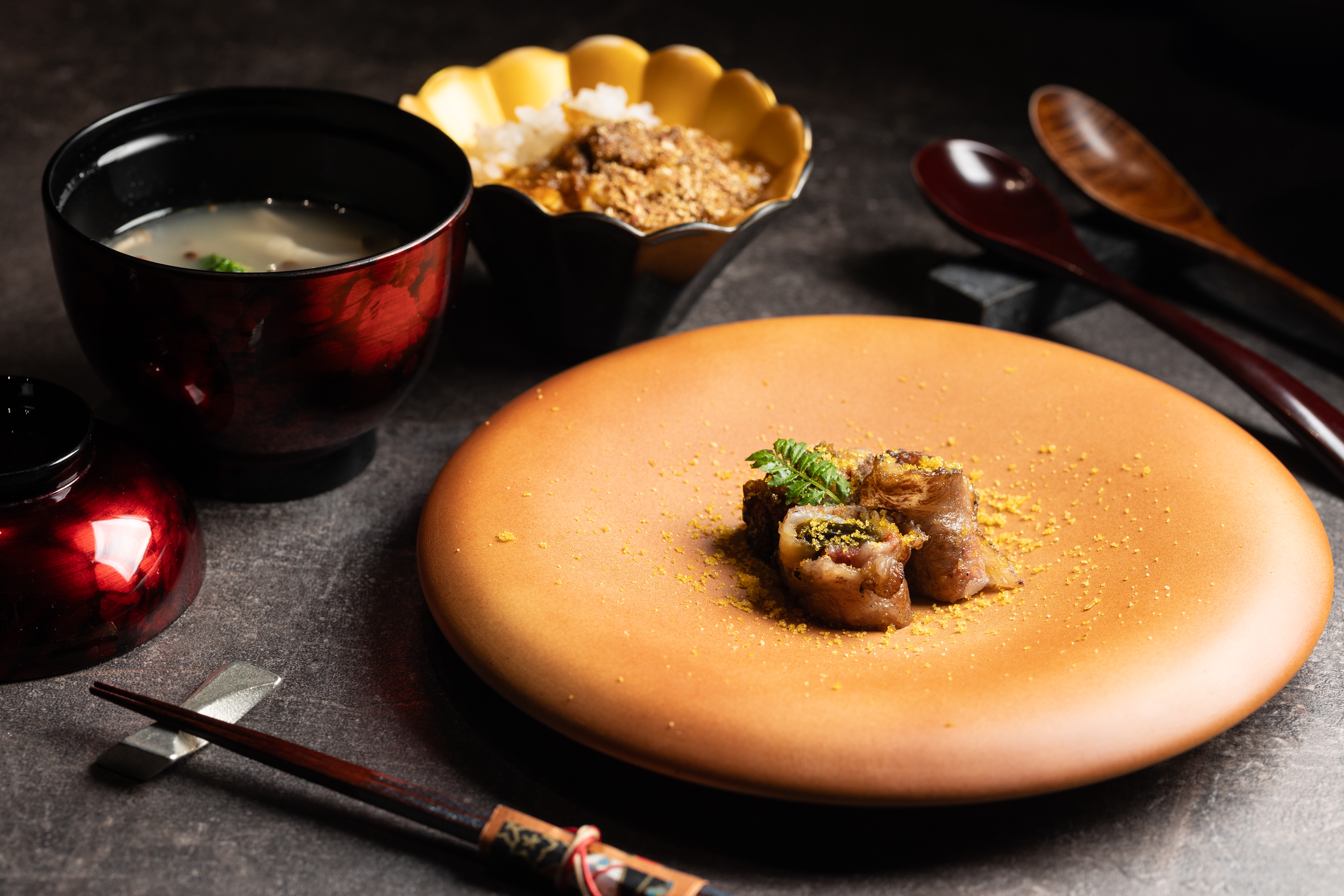「親子捲」以油花豐富的和牛肋眼肉片捲起佃煮昆布與漬軟絲軟絲，再以紫蘇與茗荷的辛香點綴。