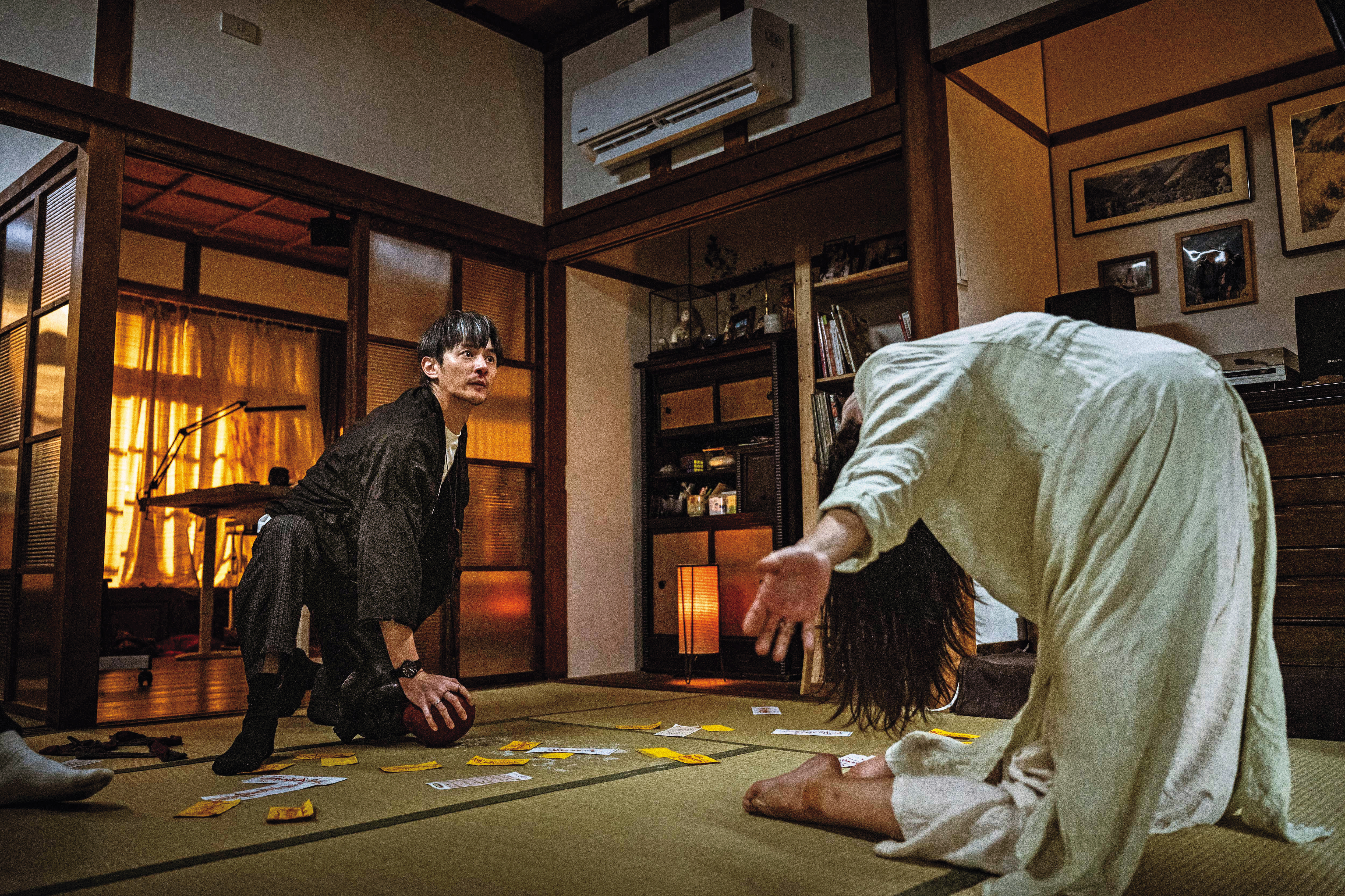 張軒睿（左）化身驅魔師對付孕婦蔡思韵（右）身上的邪靈，片中日式房舍空間符合角色受困的氣氛。（天予電影提供）