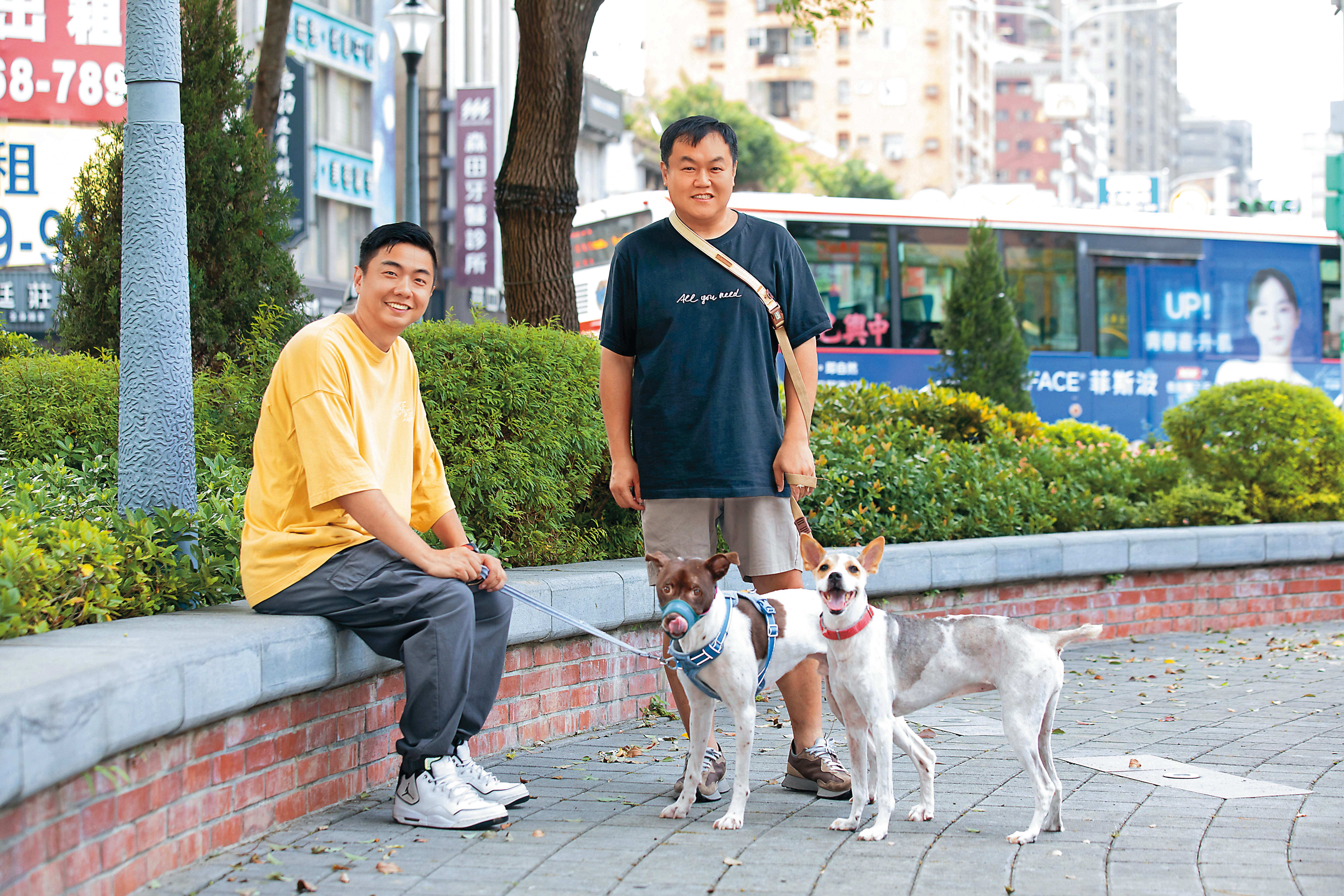 熊爸（左）跟司徒建銘（右）一起帶著2隻狗狗外出，左邊是QQ，右邊是妮妮，被牽著的QQ很緊張。
