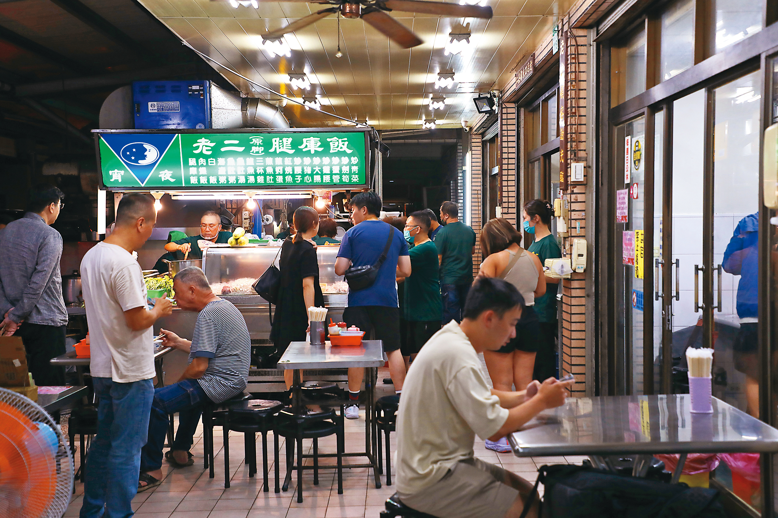 深夜時分，在騎樓下開店的老二腿庫飯人潮川流不息。