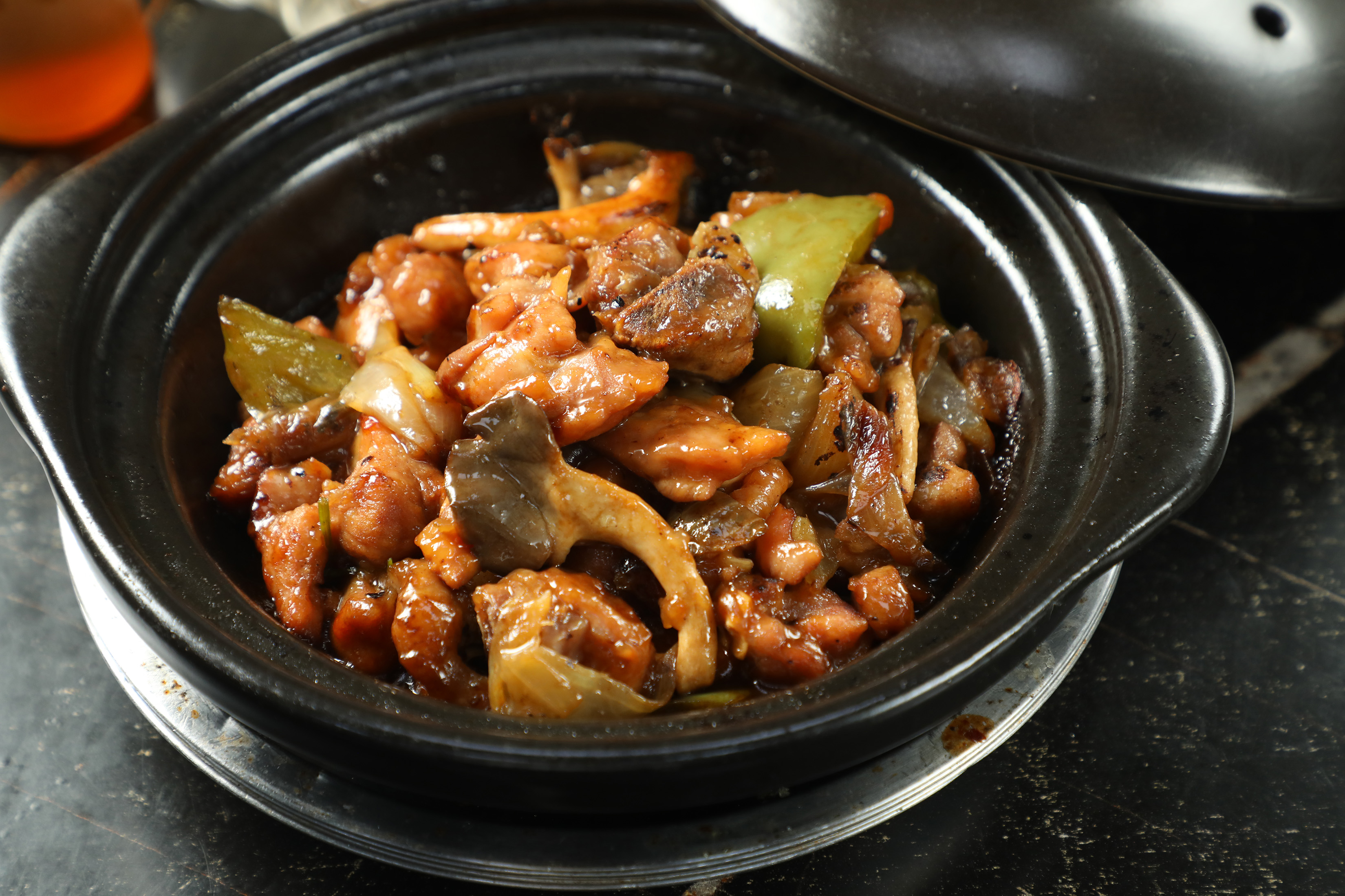 「啫啫雞煲」雞肉滑嫩、醬香濃郁，味道鮮美家常，吸飽醬汁的青椒更是精華所在。（港幣100元／份，約NT$386）