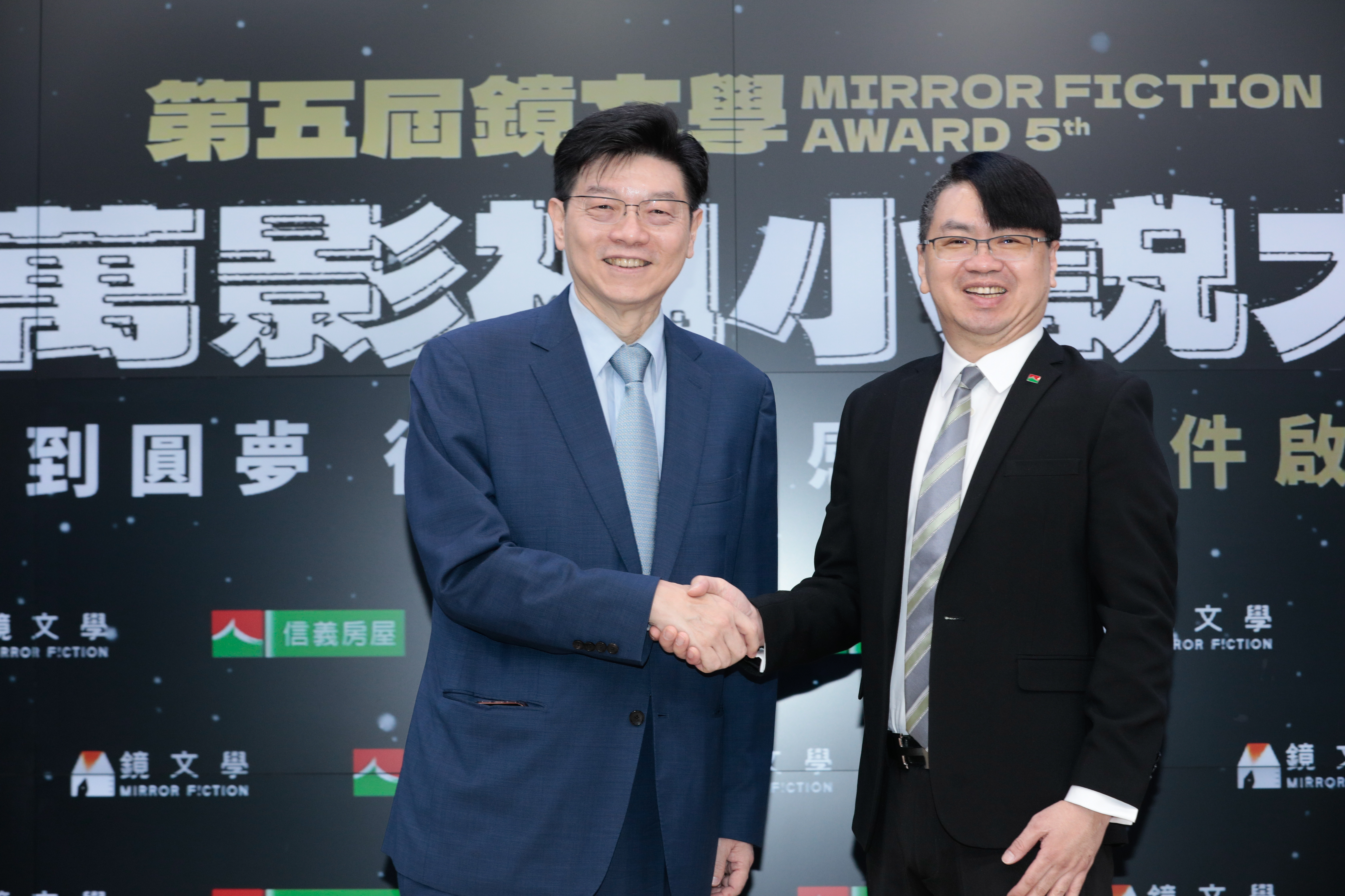 鏡文學董事長裴偉（左）、信義房屋副總經理信泓浚（右）宣告鏡文學與信義房屋攜手合作，為台灣原創故事打造邁向國際的堅實平台。