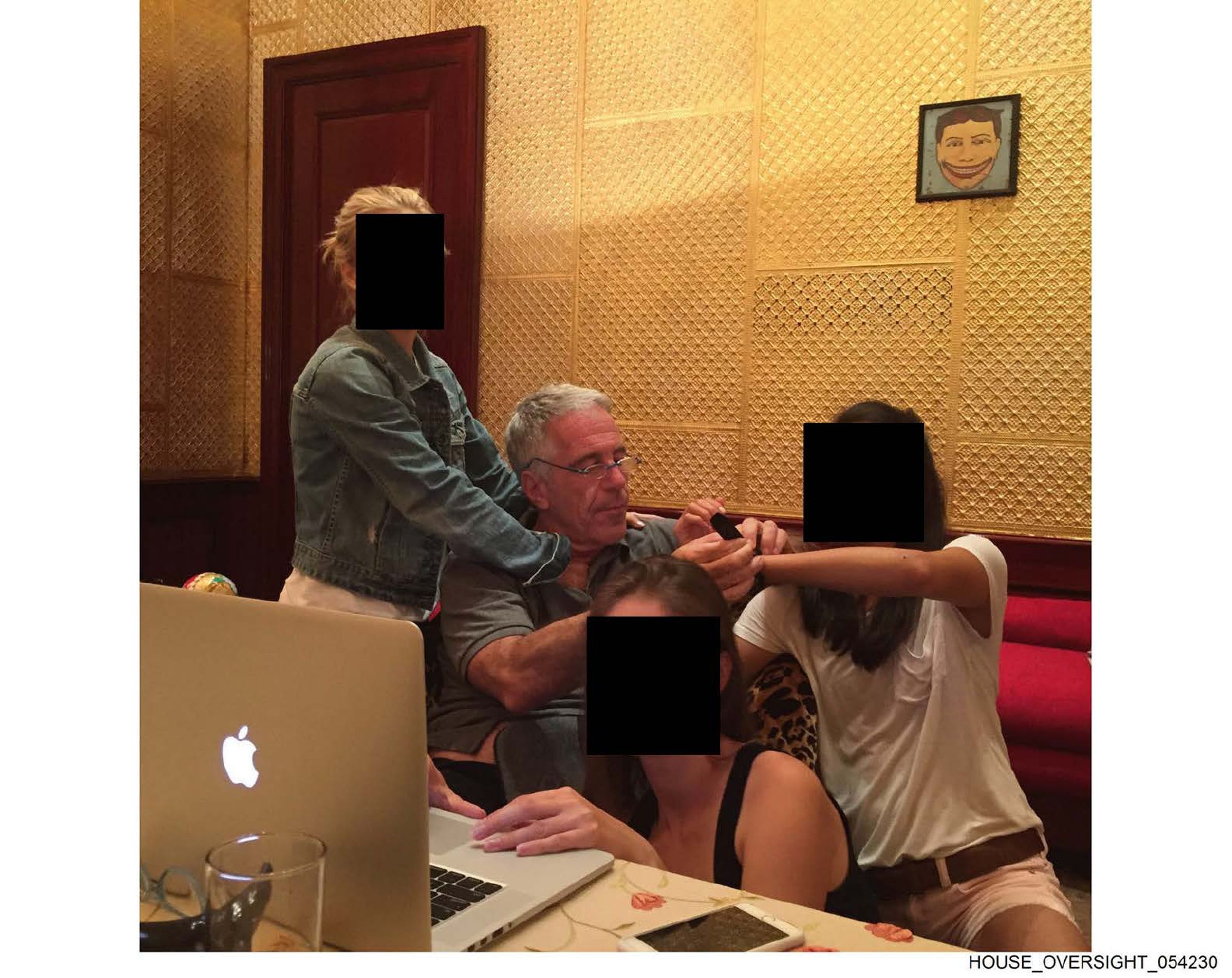 艾普斯坦與多名女子合影,她們的臉部被遮蔽、身分不明。(翻攝House Oversight Committee)