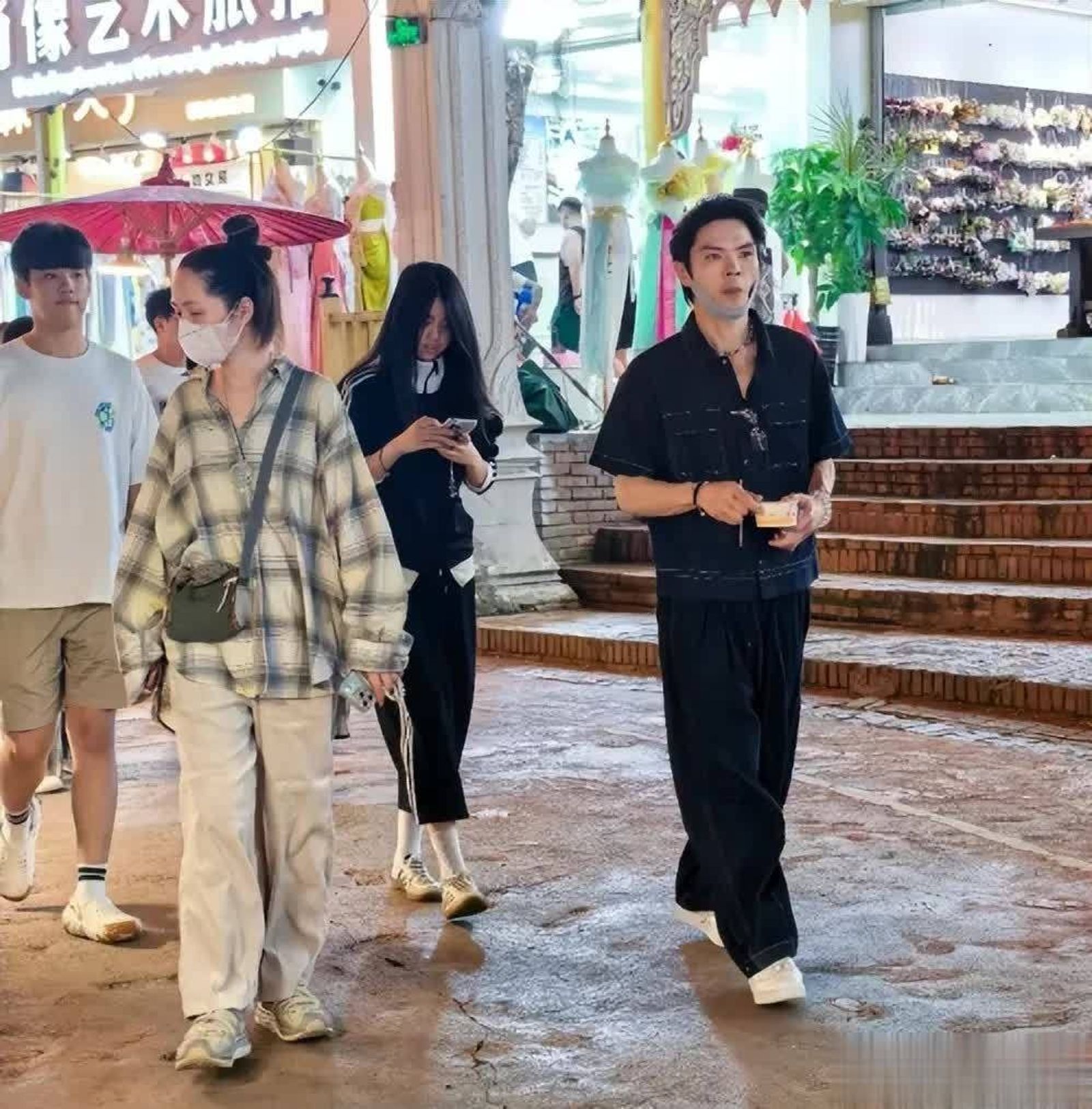 郭碧婷（左）綁著丸子頭、穿著休閒服逛夜市，向佐則一邊品嚐當地小吃，一邊陪伴家人。（翻攝微博）