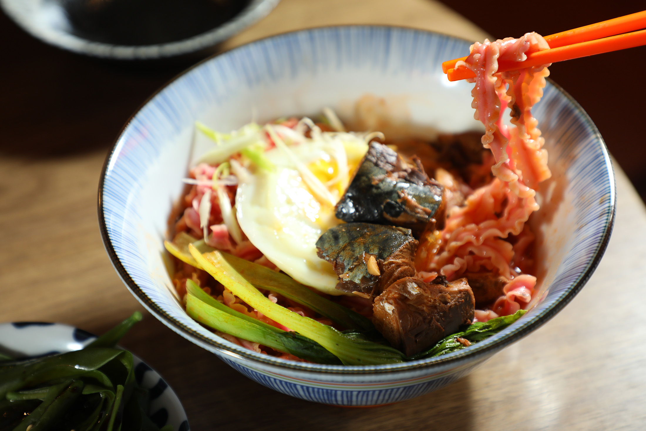 夜宵森食屋發想自「颱風麵」的「茄汁鯖魚麵」，除魚罐頭、蔬菜與雞蛋等標配，還選用屏東製作的紅龍果麵。（150元／碗）