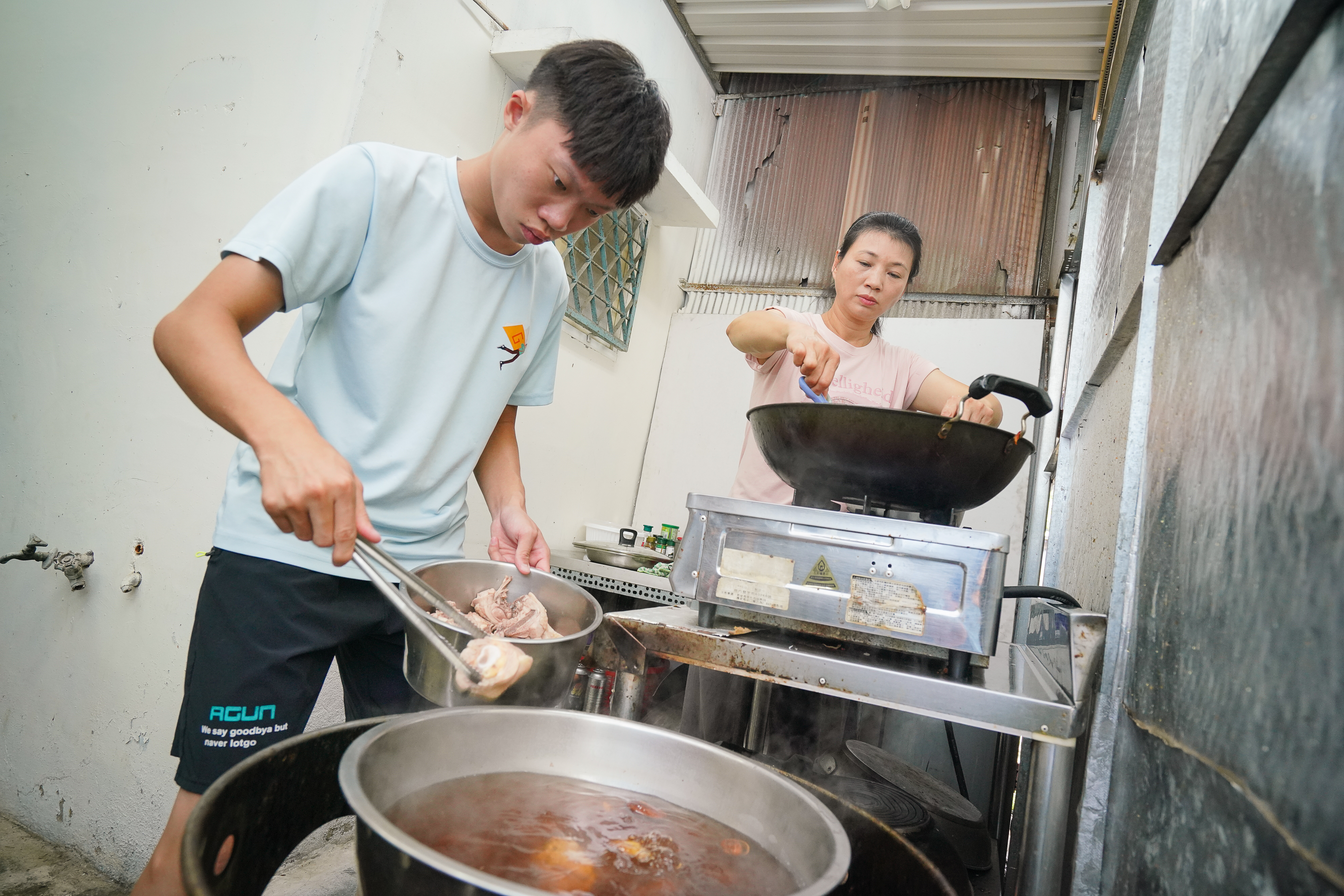 張豔君（右）為方便照顧罕病兒（左），以家鄉廣西的剁椒、小魚乾和蒜頭製作干貝醬創業，兒子蕭禾翊（左）也會貼心主動幫忙。