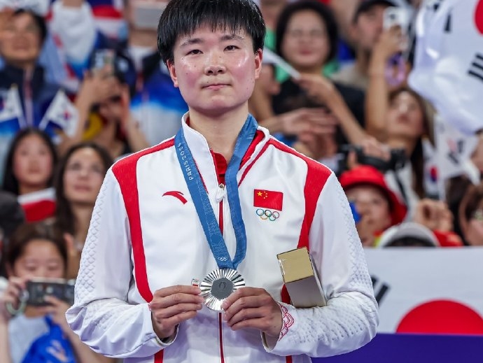 何冰嬌奪下巴黎奧運羽球女單銀牌，右手拿著小小的西班牙國旗，為了與因傷退賽的瑪琳分享這份榮耀。（翻攝自BWF微博）