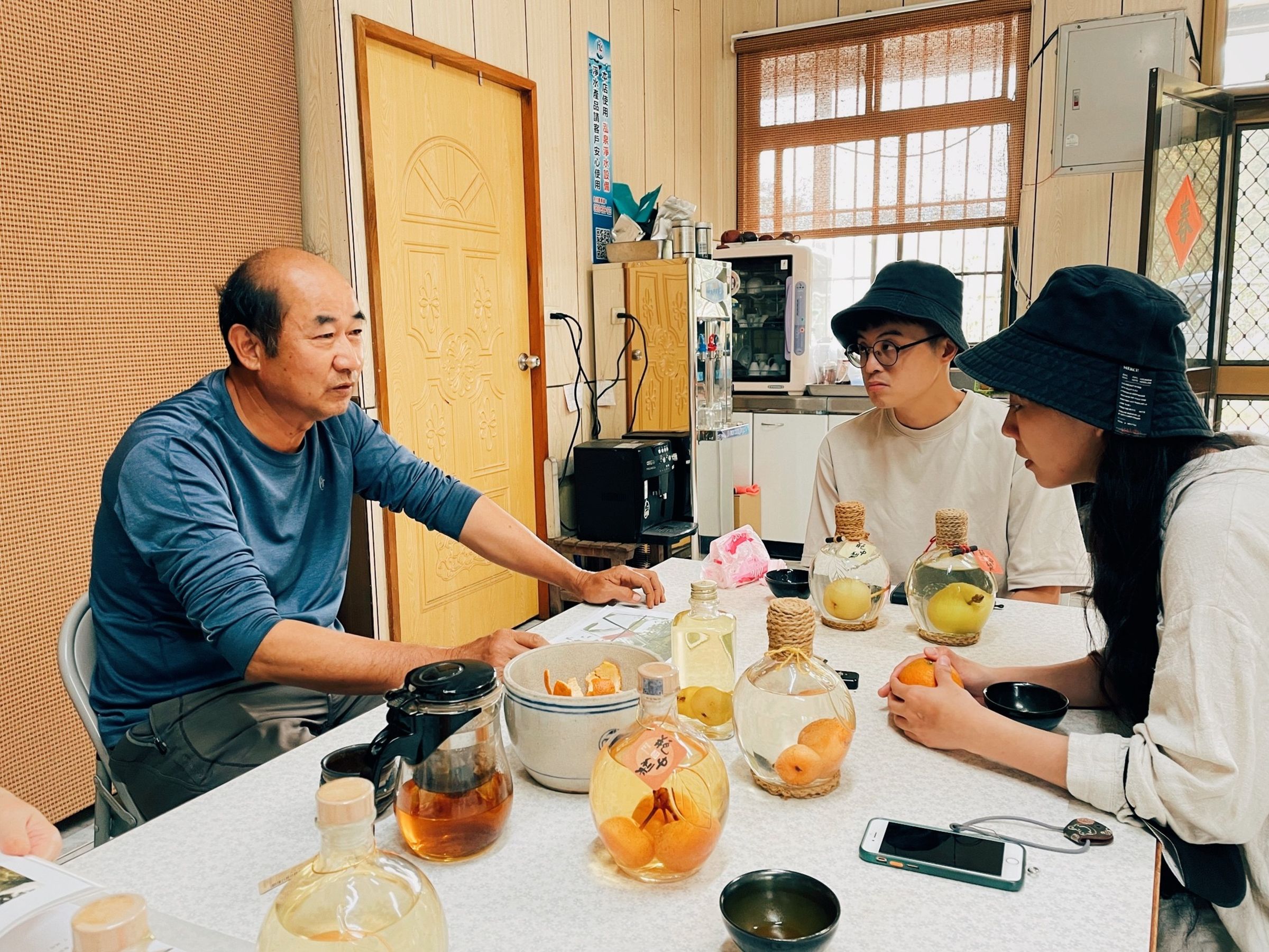 何安妘（右1）以台中東榮農場老闆蘇光明（左1）製作「瓶中梨」的甘苦，轉化成帶有奇幻風格的作品〈酒是機率－永不分離的機率〉。右2為繪製〈酒是遺憾－黑米糰子與酒〉的漫畫家大錢。（聚場文化提供）