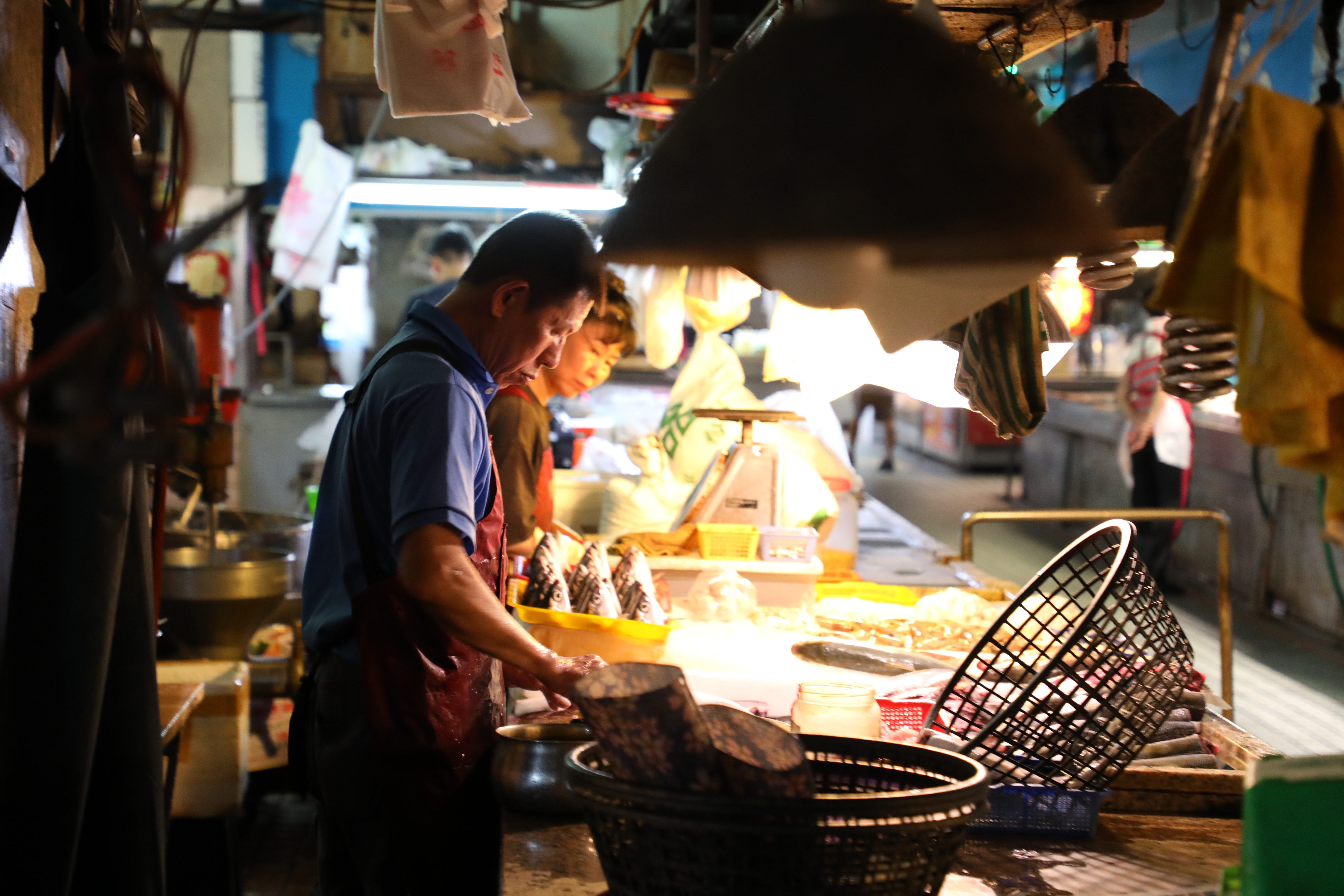 昏黃燈光下的鮮魚攤，是海港城市的一景。