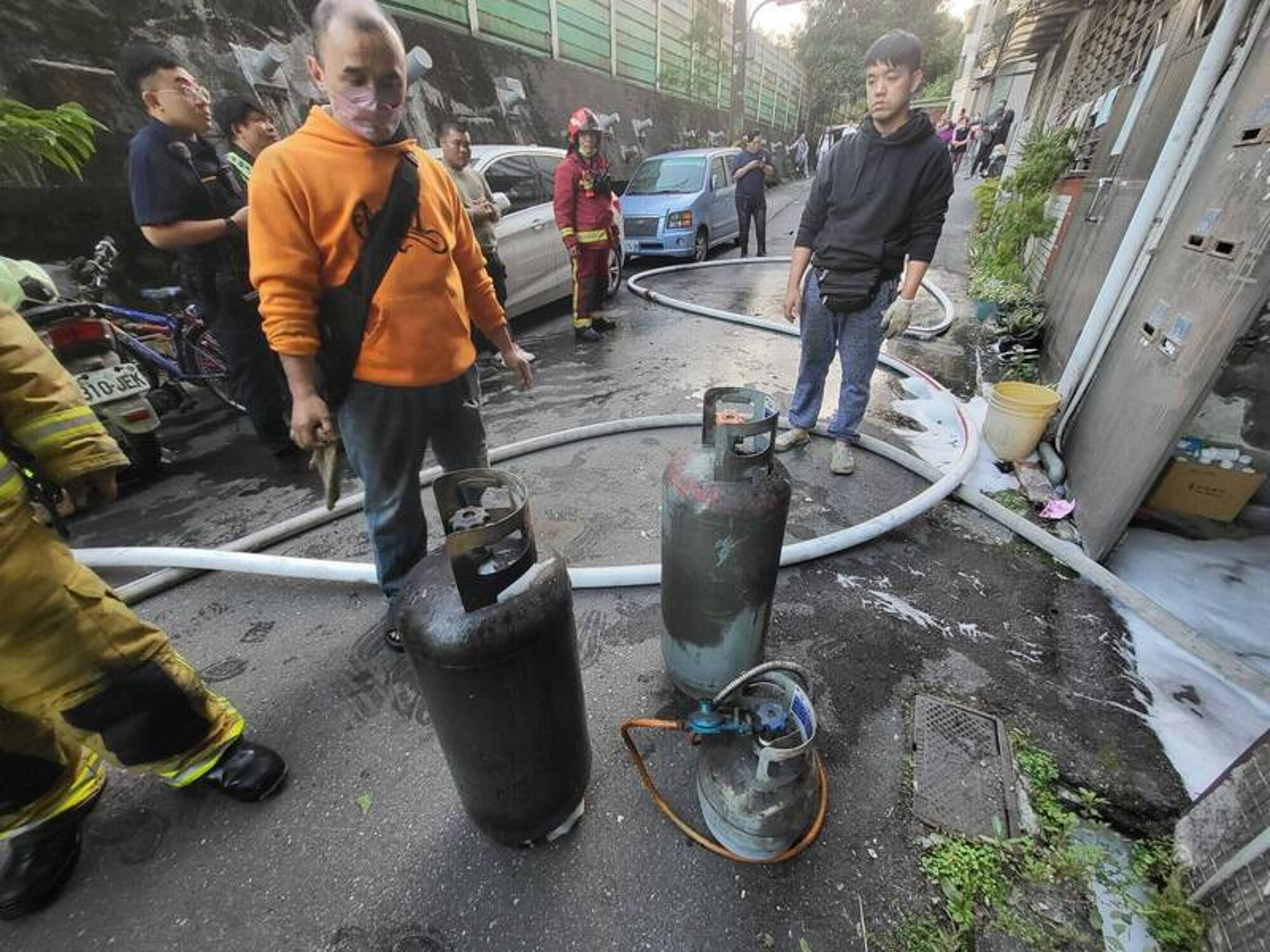 消防人員在火場客廳拉出3支瓦斯桶,解除爆炸危機。(消防局提供)