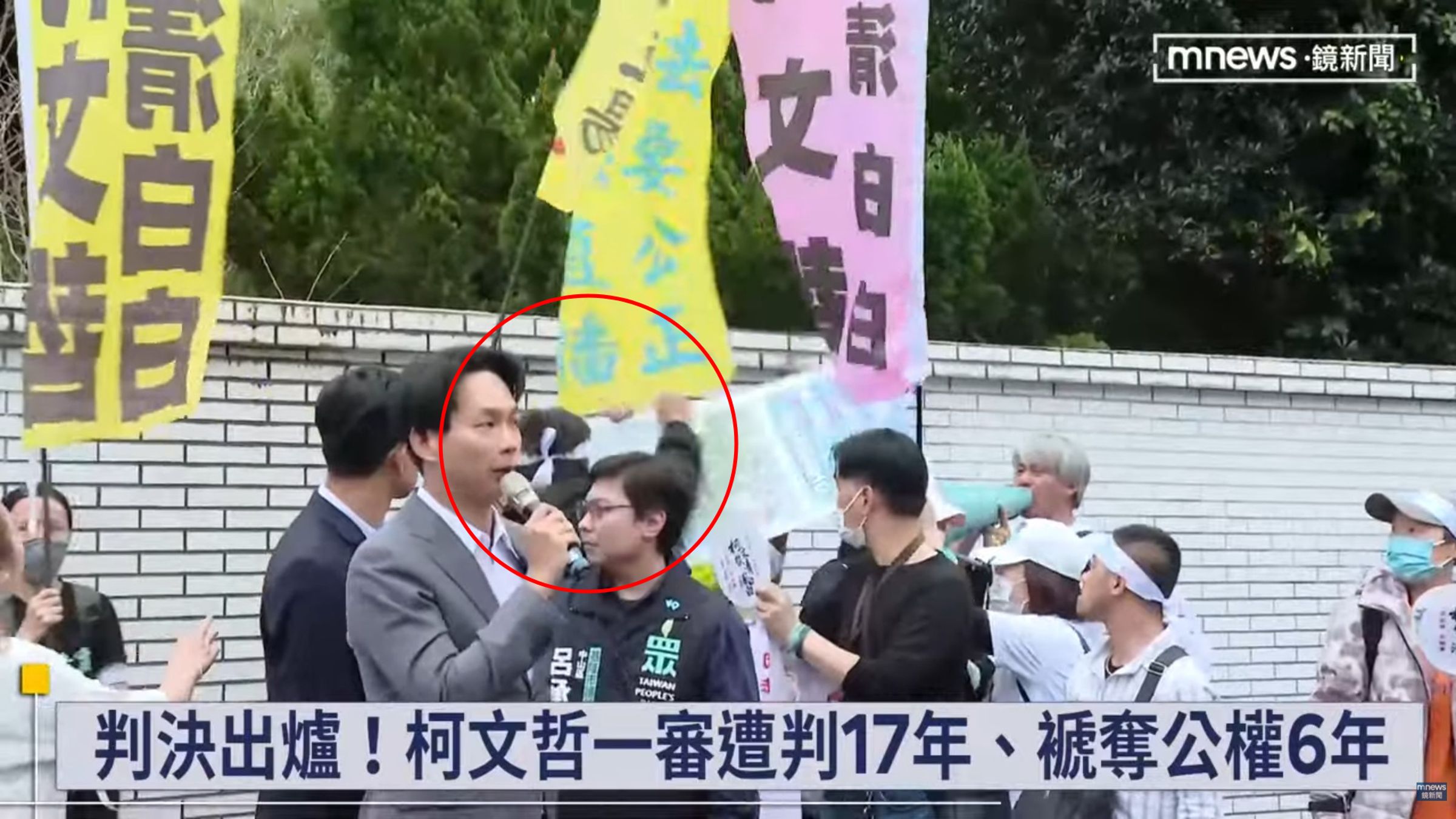 小草（紅圈處）揮拳痛毆黃衣男。（翻攝鏡新聞YT）