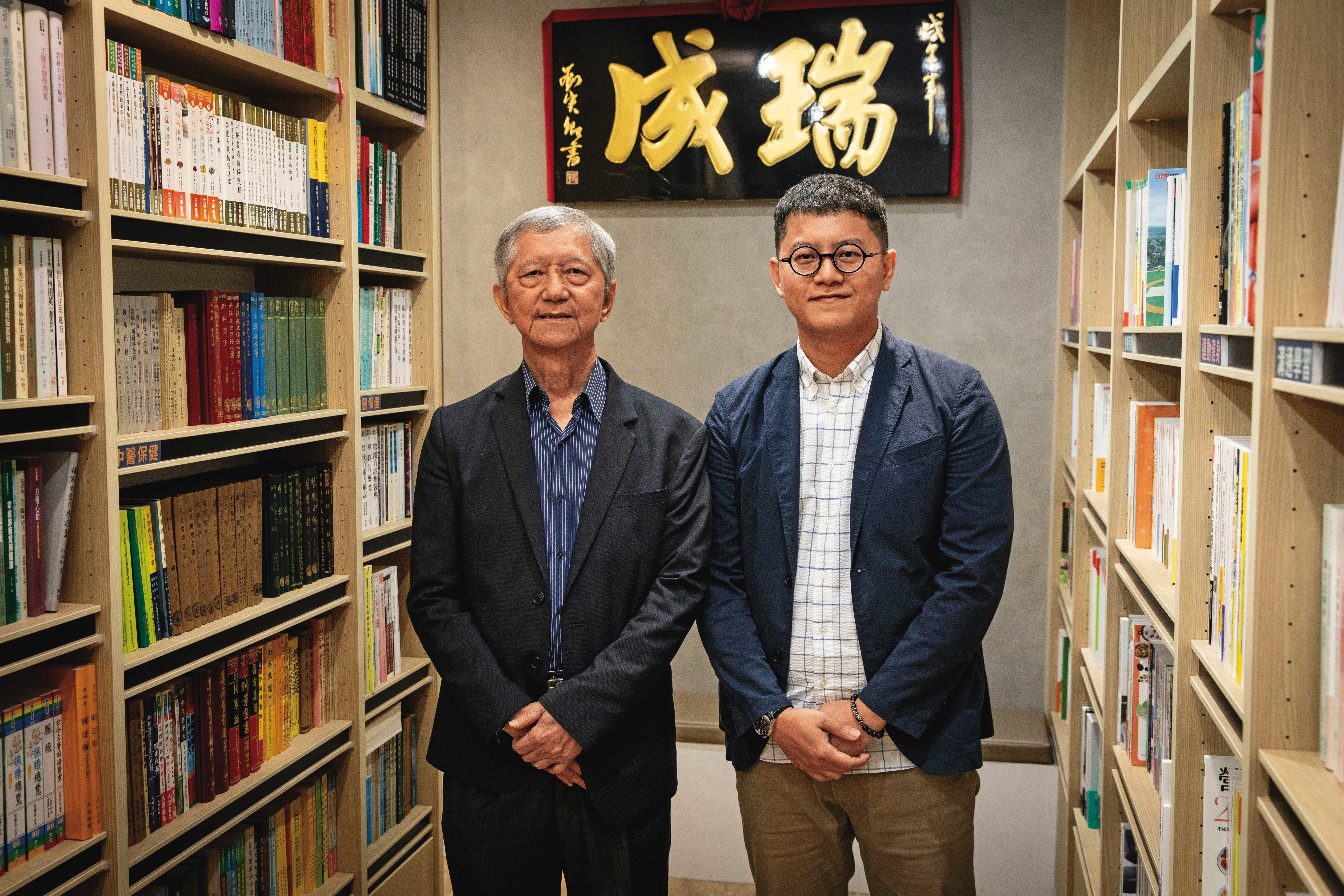 台中瑞成書局，1912年創立，是全台最老的書局，以豐富的宗教藏書聞名，圖為第三代董事長許欽鐘（左）與第四代副總經理許永奕（右）。