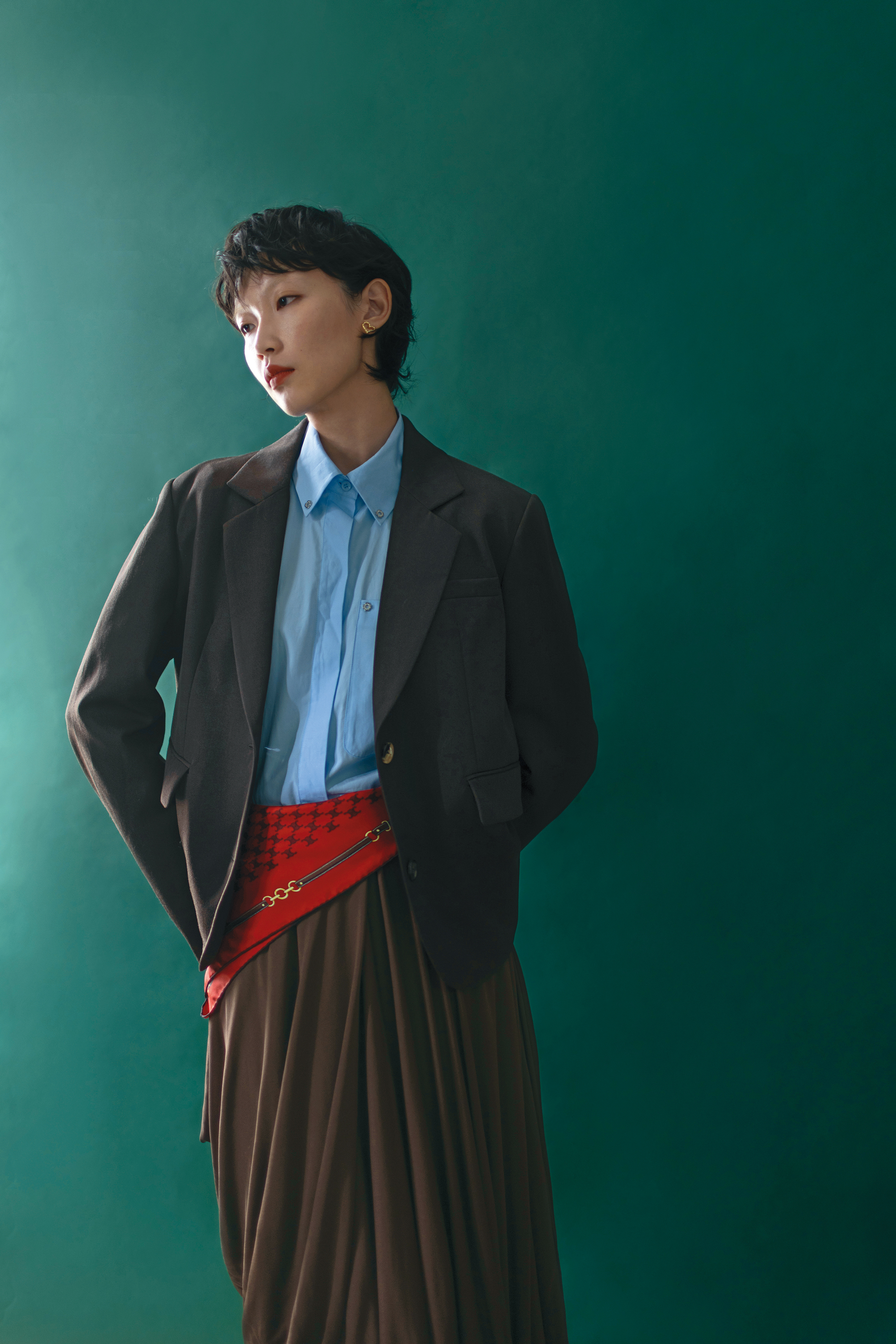 深棕色外套 NT$74,000 by LOEWE／藍色襯衫 價格店洽 by Maje／棕色打褶裙 NT$78,000 by LOEWE／金色愛心耳環 價格店洽 by Maje／紅色印花絲巾 價格店洽 by CELINE