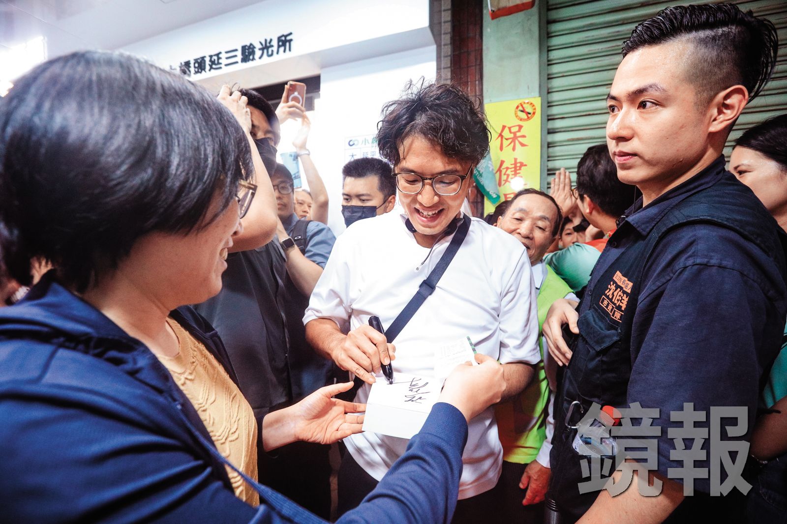 沈伯洋（中）民調急起直追，掀起洋流巨浪，支持者紛紛要求簽名合照，維安問題刻不容緩。（鏡報鄒保祥）