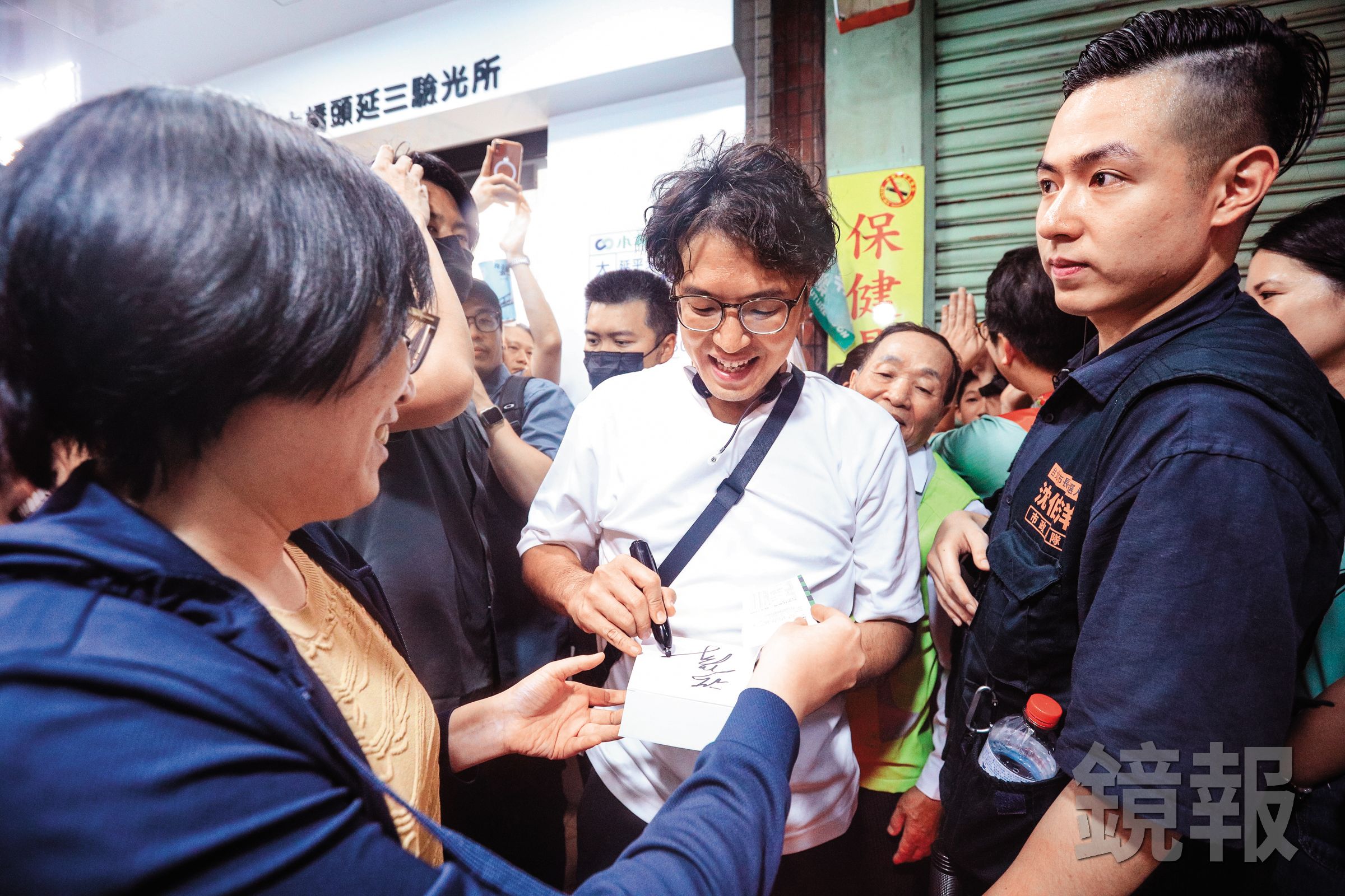 沈伯洋(中)民調急起直追,掀起洋流巨浪,支持者紛紛要求簽名合照,維安問題刻不容緩。(鏡報鄒保祥)