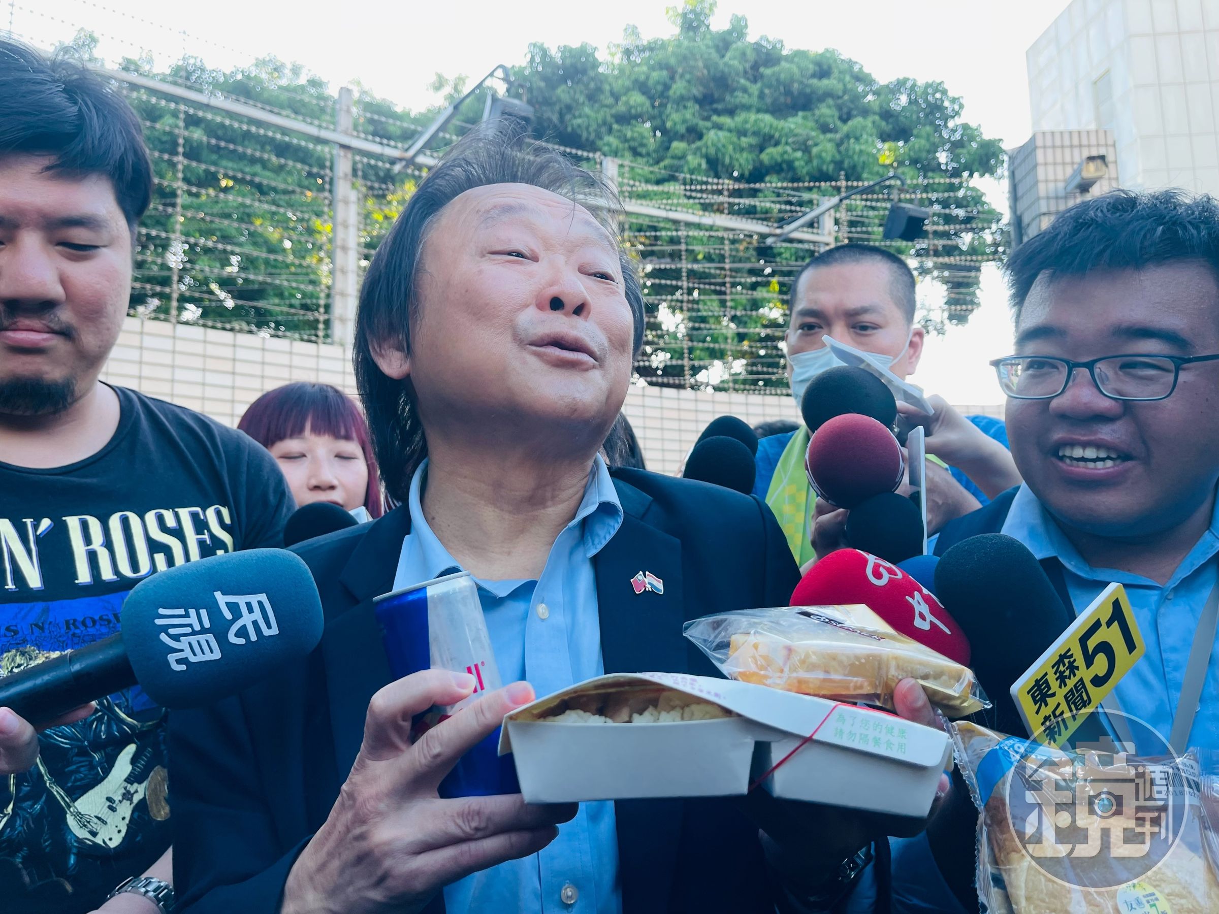 王世堅手持雞鴨便當、起酥蛋糕、能量飲料,還有要送給柯文哲室友的麵包。