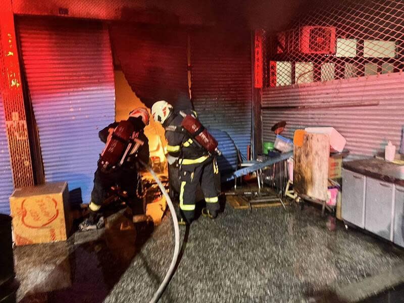 警方到場掀開鐵捲門進入火場，發現民宅內轎車起火。（翻攝畫面）
