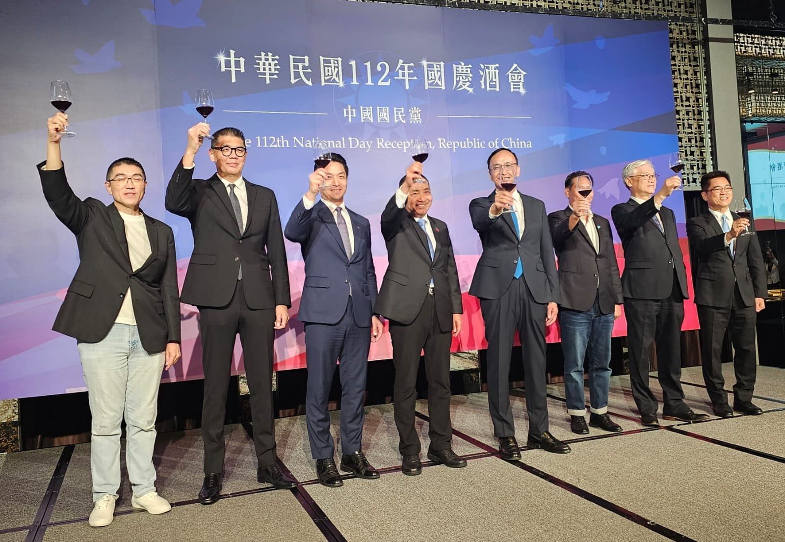 連勝文(左起)、謝國樑、蔣萬安、侯友宜、朱立倫等人站在講台上,手上拿紅酒杯做出乾杯手勢。(翻攝連勝文臉書)