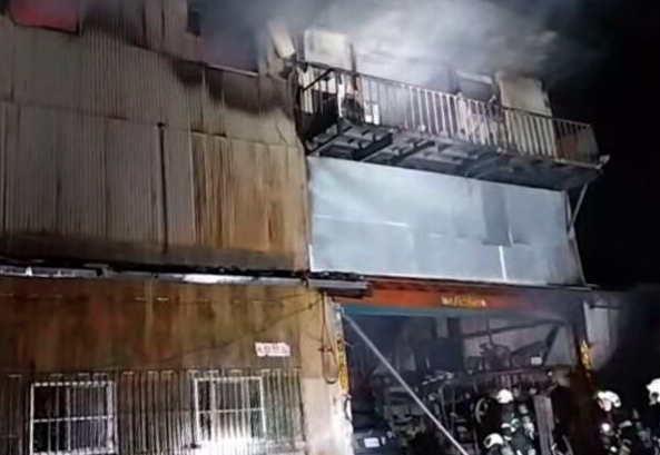 消防局出動百餘名救災人員與無人機、救災機器人趕抵南港火場，全力阻止火勢向鄰近林木蔓延。（翻攝畫面）