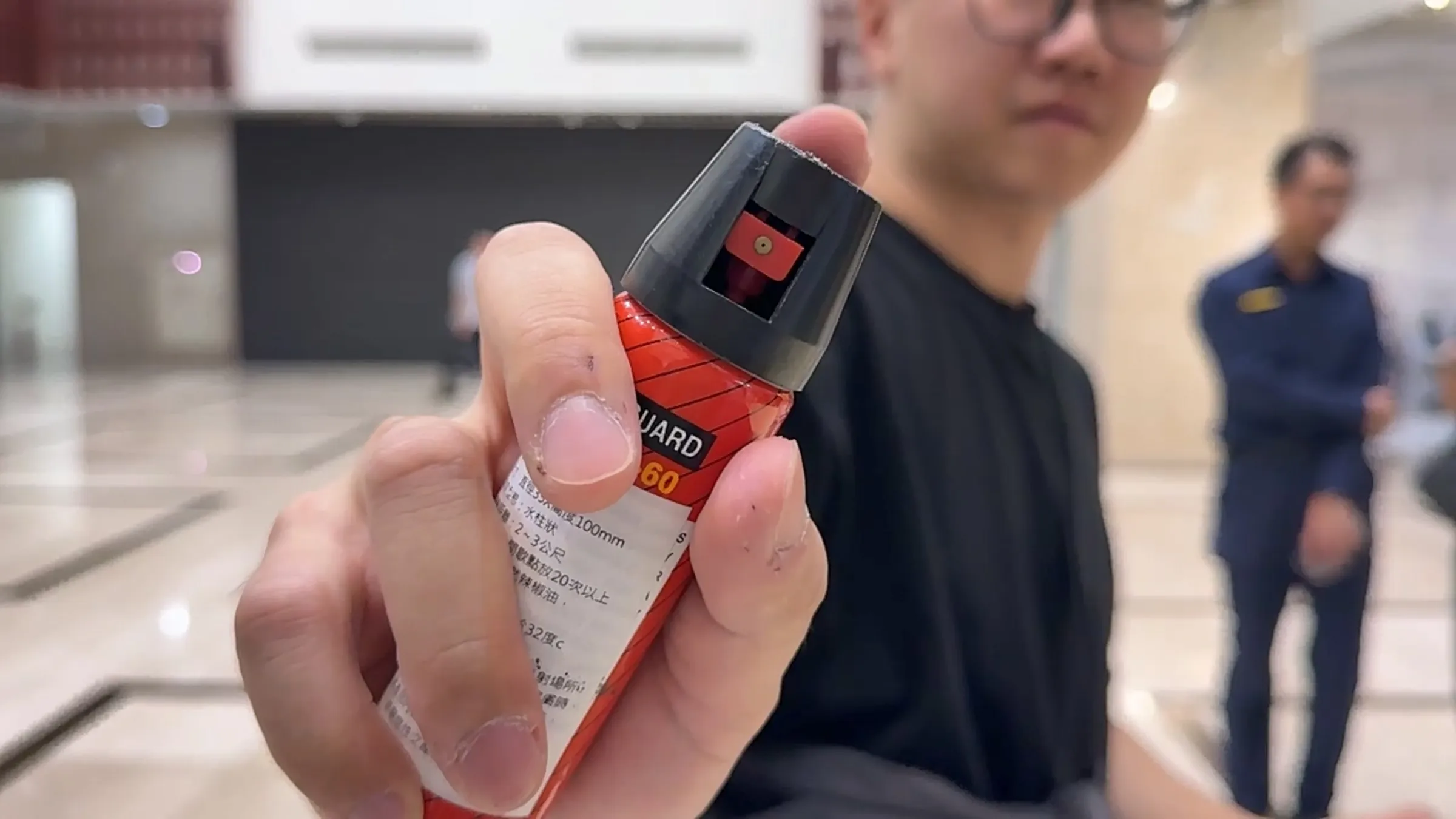 周俊銘操作辣椒水噴霧不慎導致液體滲漏，卻未按SOP處理，反而邊走邊噴。（翻攝畫面）