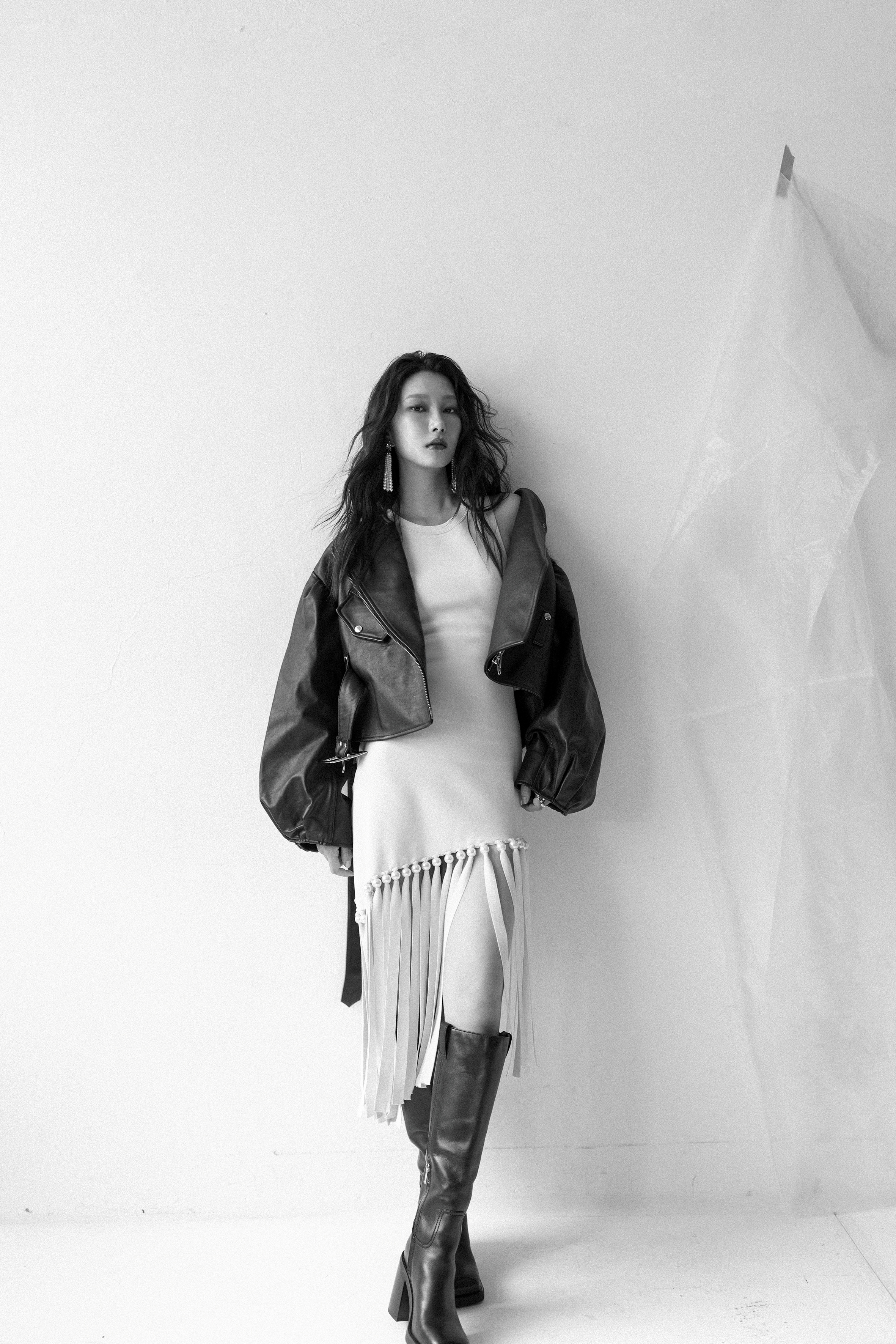 短版皮衣外套 NT$91,800 by Simone Rocha、米白色珍珠滾邊流蘇洋裝 NT$12,090 by SANDRO、黑色長靴 價格店洽 by MICHAEL KORS、星星珍珠耳環 私人提供。