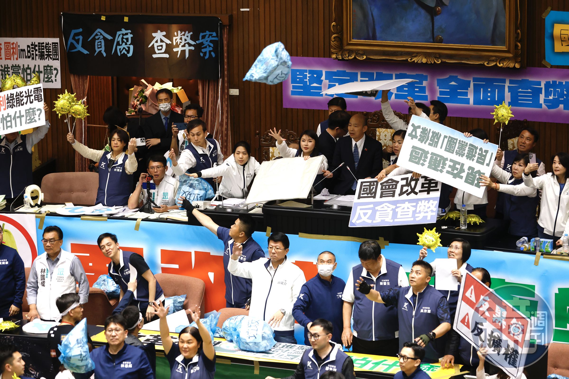 民進黨團朝主席台狂丟「垃圾」,但都被手持太陽造型氣球、高喊「讓陽光照進國會」的國民黨團擋下。