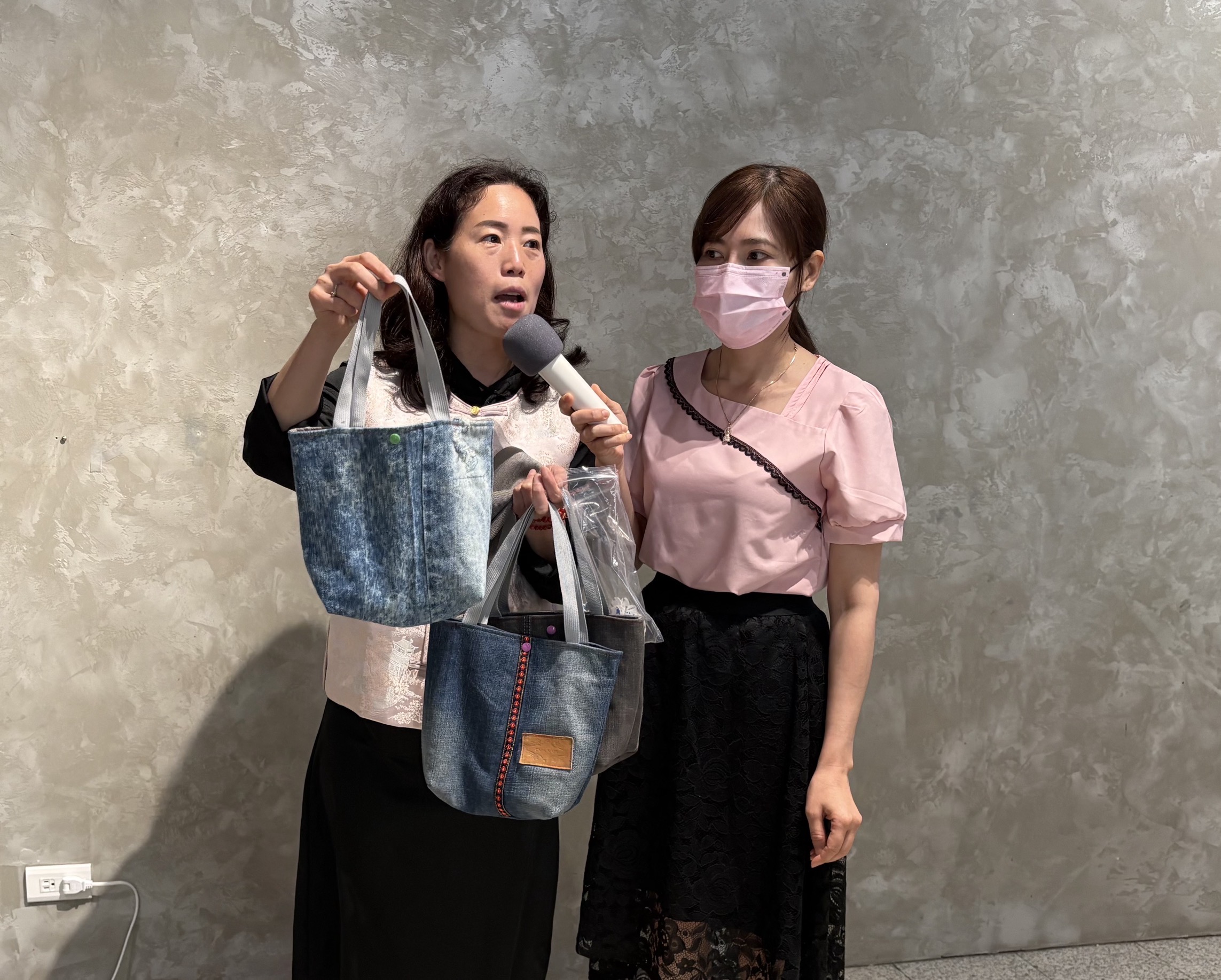 參與活動的新住民開心展示牛仔布包成品。(移民署提供)