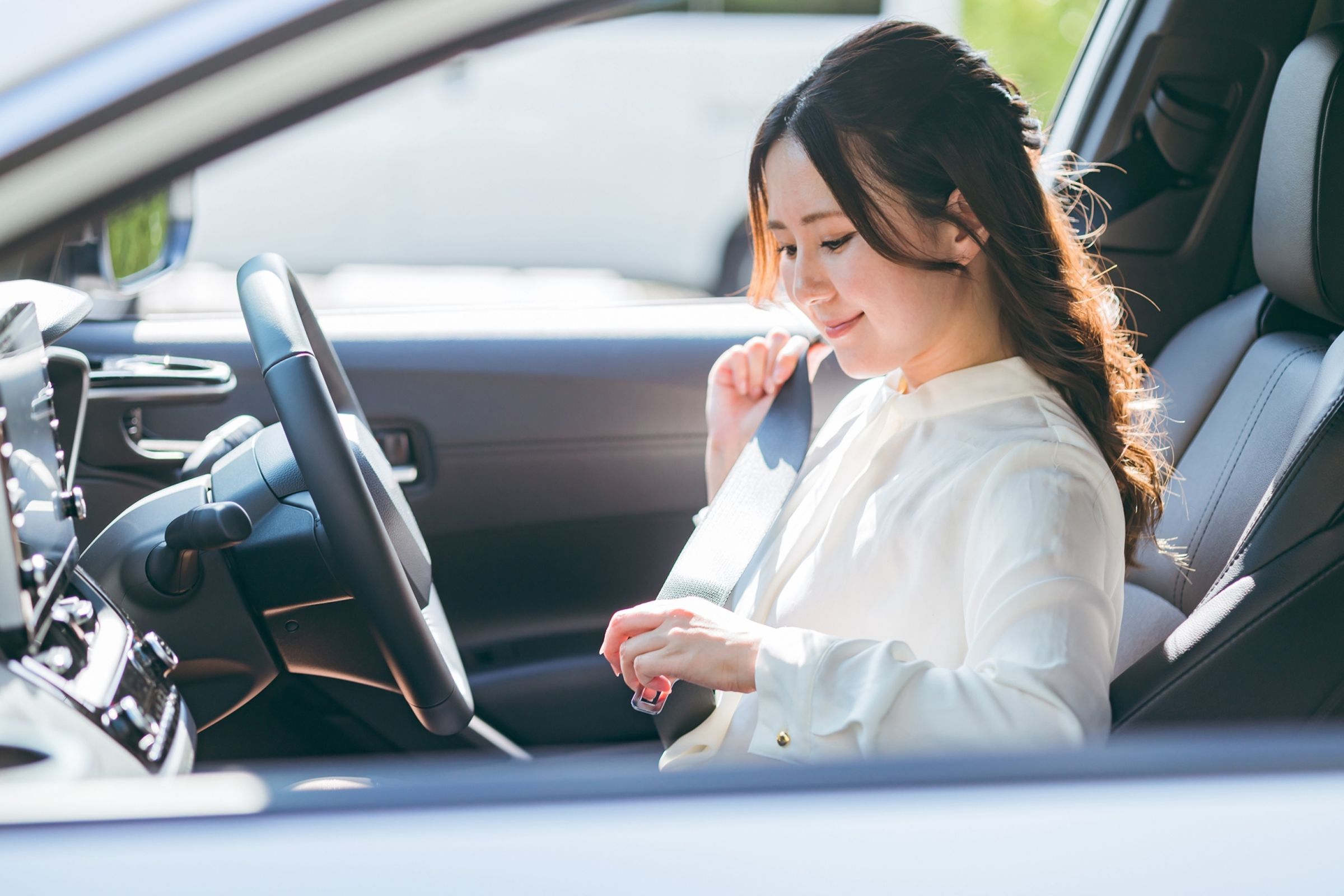 一名女子因胸部大,開車時將安全帶從左腋下繞過胸部下面繫上,被警方開罰單。(示意圖,非當事人,photoAC)