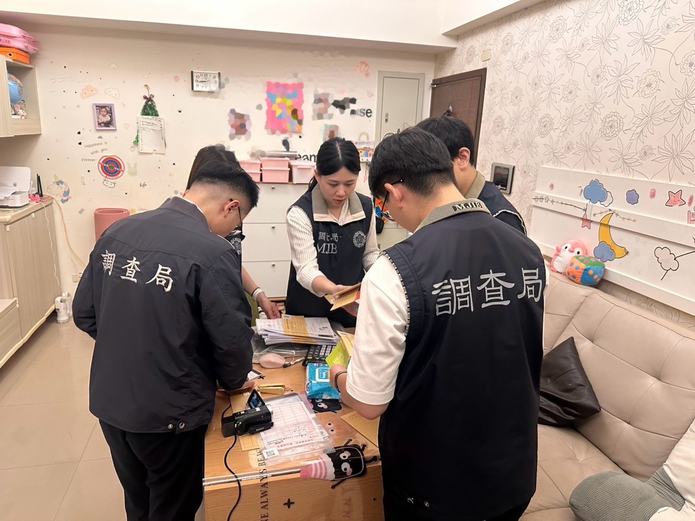 調查局在搜索現場清點地下通匯業者帳冊資料。（調查局提供）