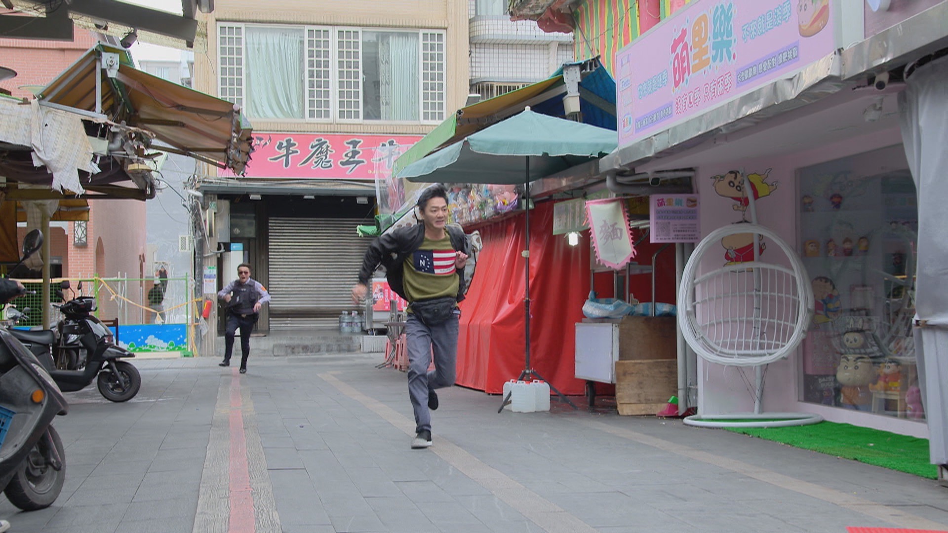 何豪傑《好運來》飾演警察，劇中追捕流動攤販，跟藍葦華你追我跑。（民視提供）