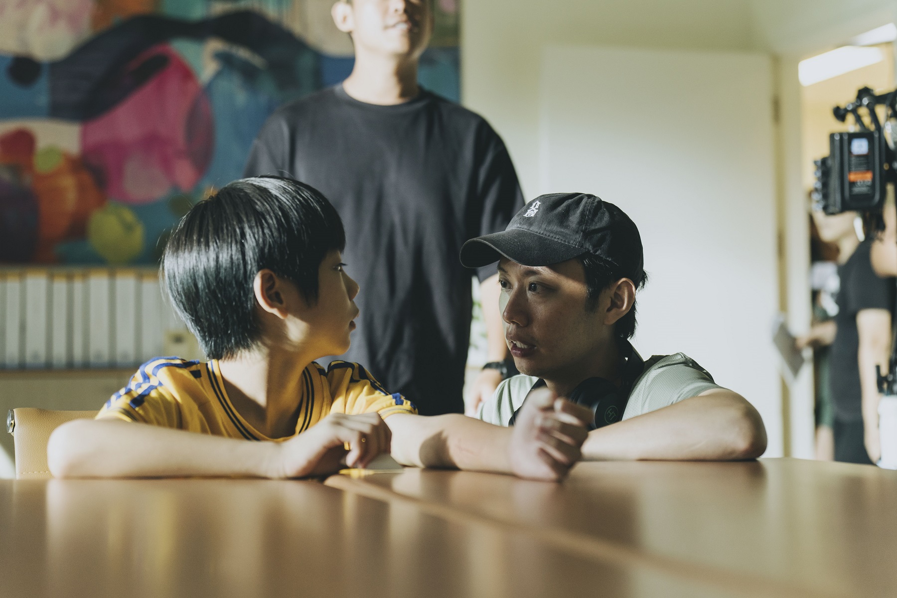 表演指導安德森(右)向小演員洪君昊(左)解說表演內容。(冬候鳥電影、文策院提供)