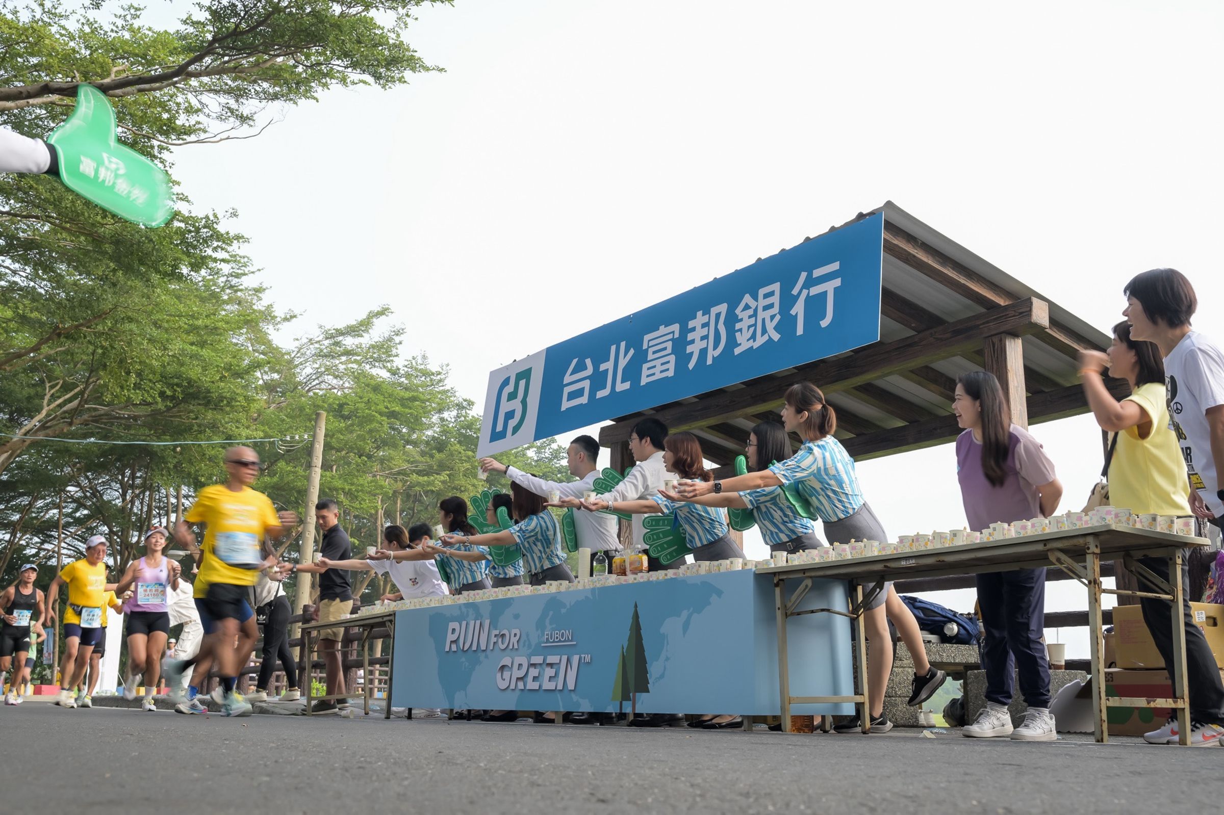 富邦金控同仁於田中馬拉松賽道上為路過的跑者提供補給與應援。（業者提供）