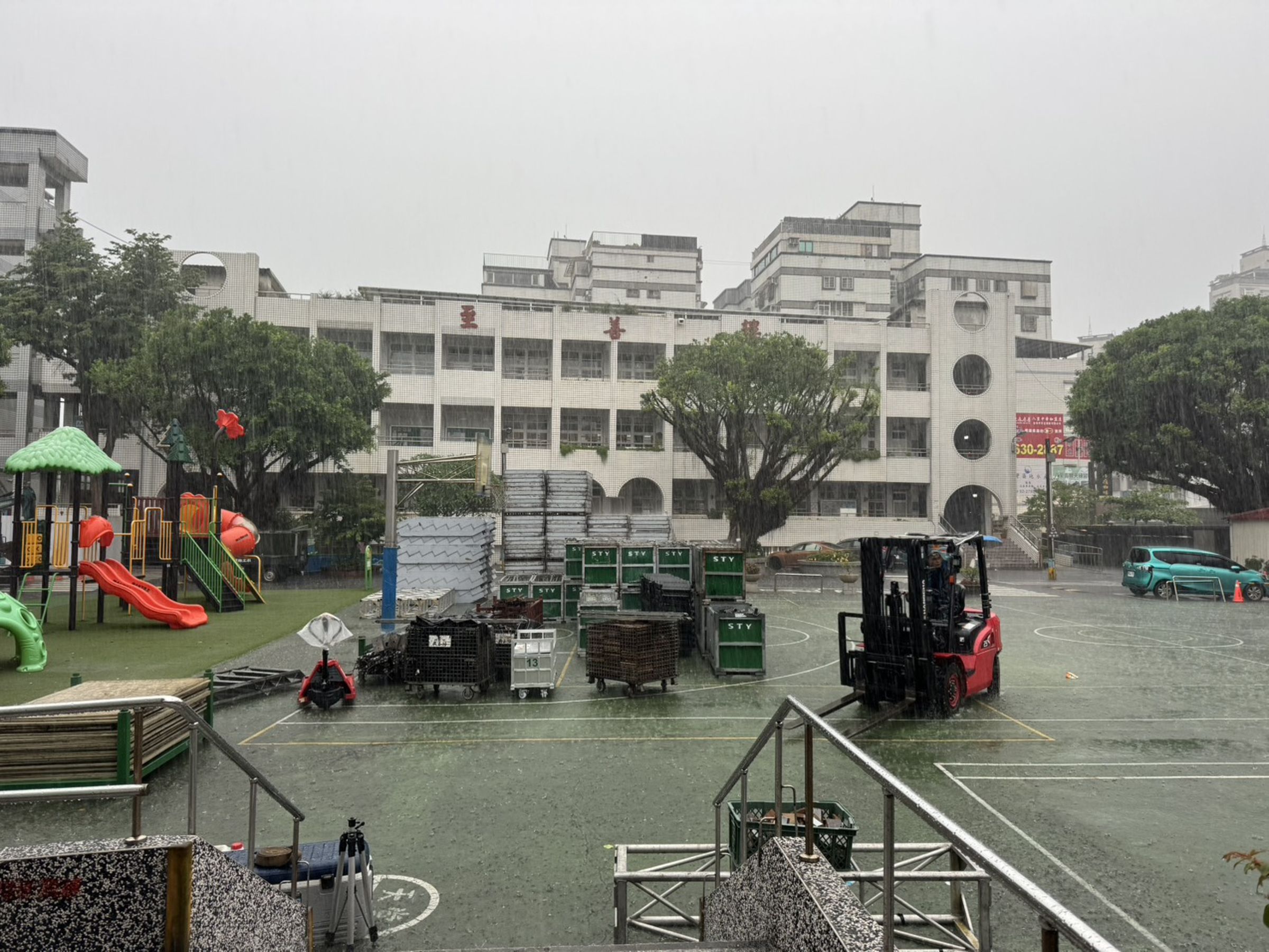 今（10日）早上，當舞台搭建隊伍前往八里國小時，發現連續降雨造成操場積水無法排退，只能宣布演出延期。（紙風車文教基金會提供）